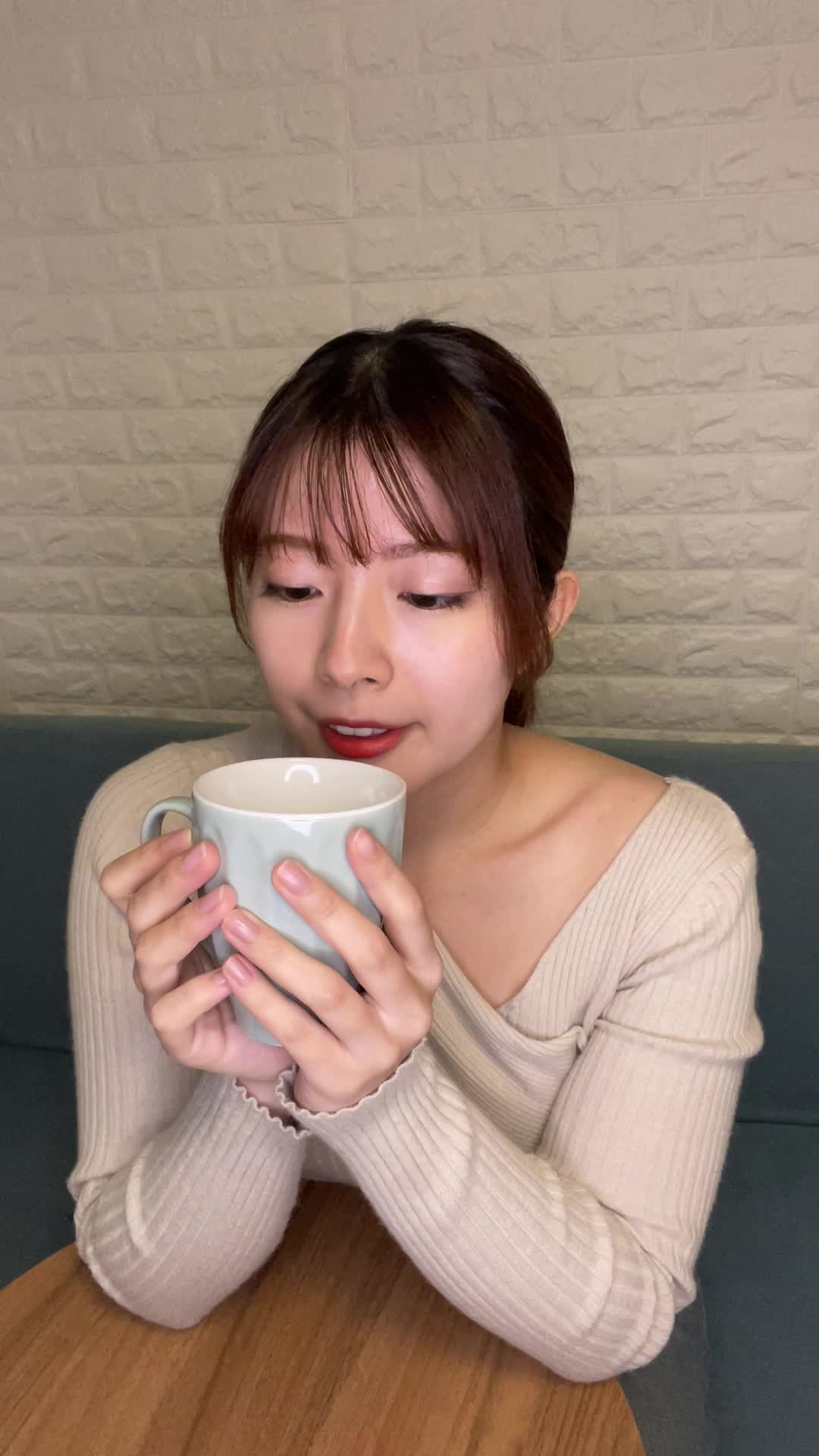 テーブルで飲み物を手に取り、「これで改善するなら試したい」と期待する微笑み