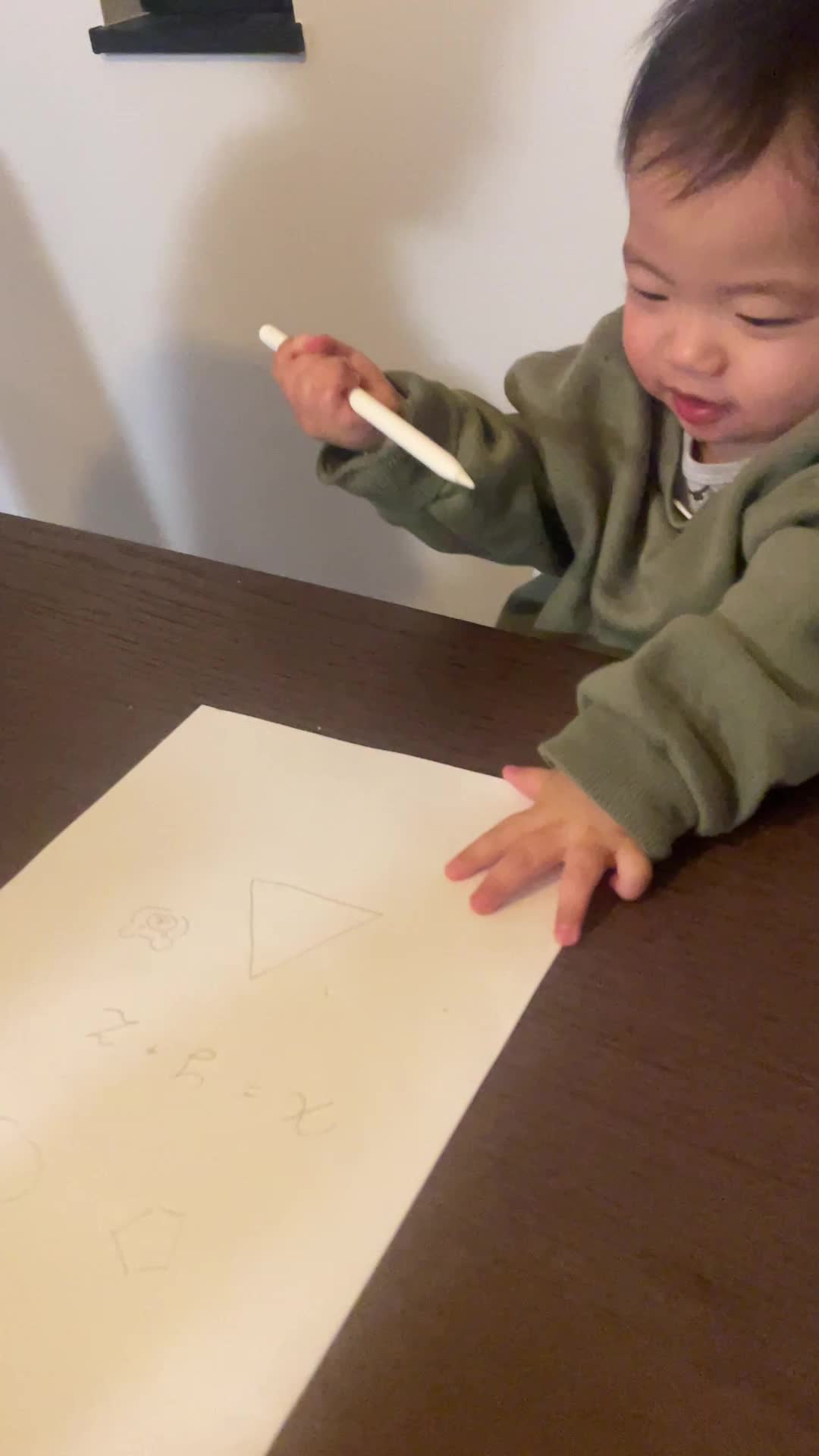 テーブルで紙に手書きで図を描きながら、「これが正解かも」と納得する姿