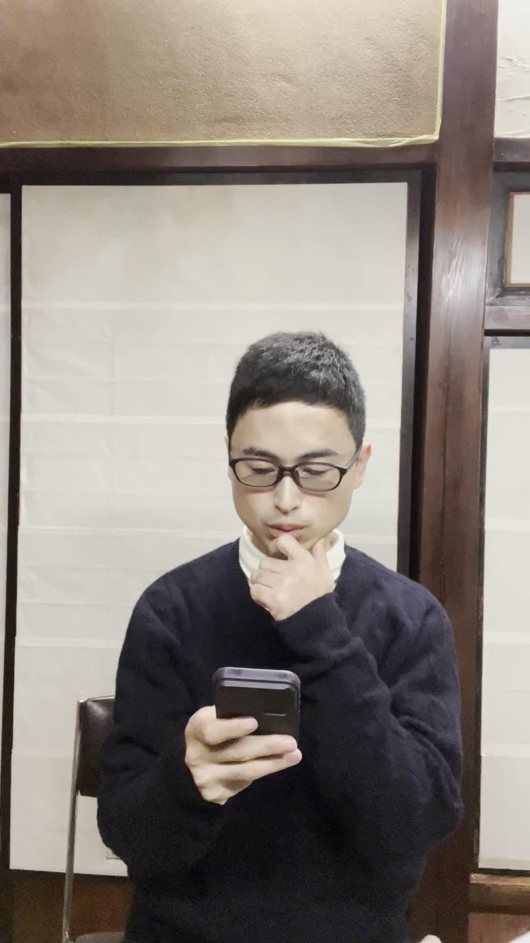椅子に腰掛け、スマホの画面を見ながら「体臭ケアの口コミを読んで安心する」表情