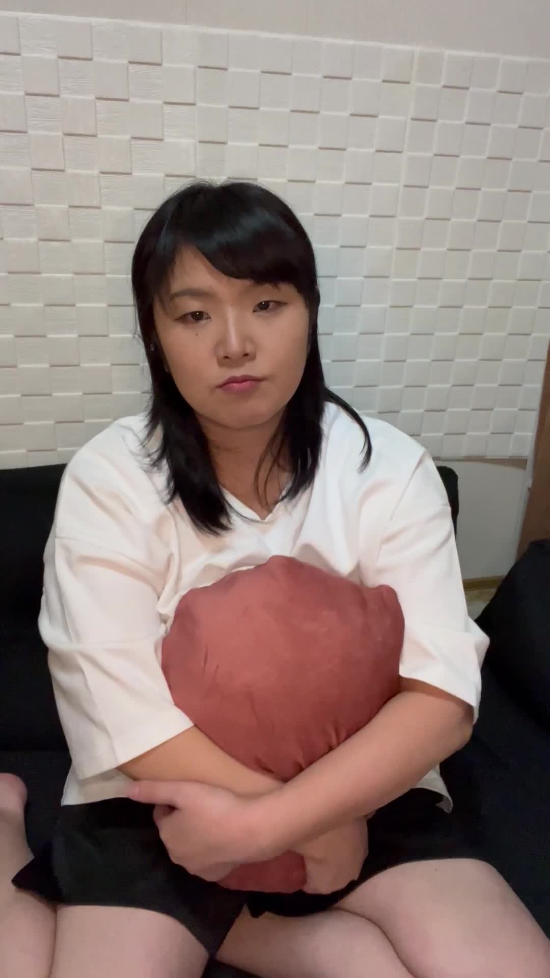 ソファでクッションを抱きしめ、「迷ってる場合じゃない！」と決断する仕草
