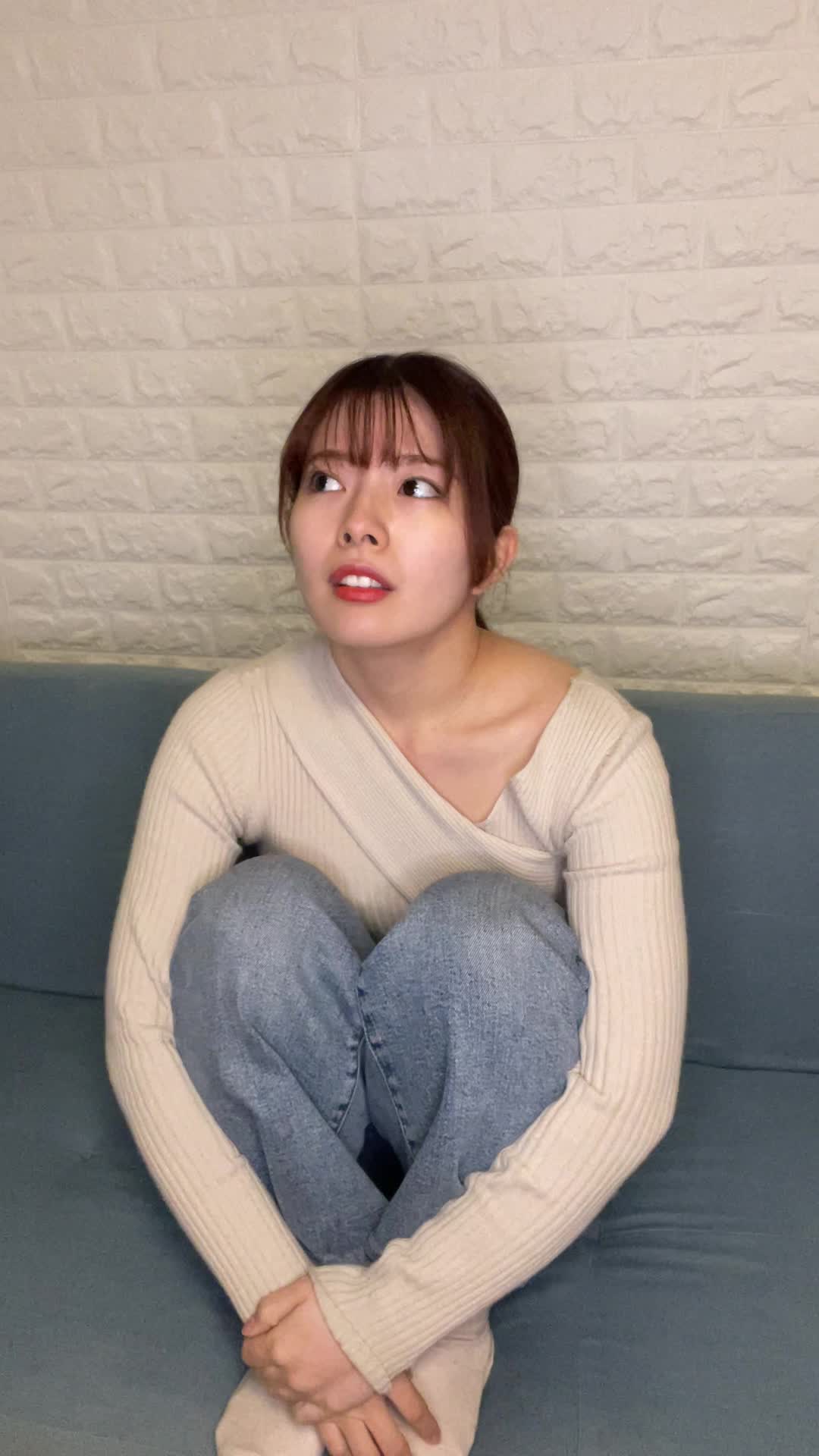 ソファで膝を抱え、「疲れやすくて何もする気が起きない」とため息をつく様子