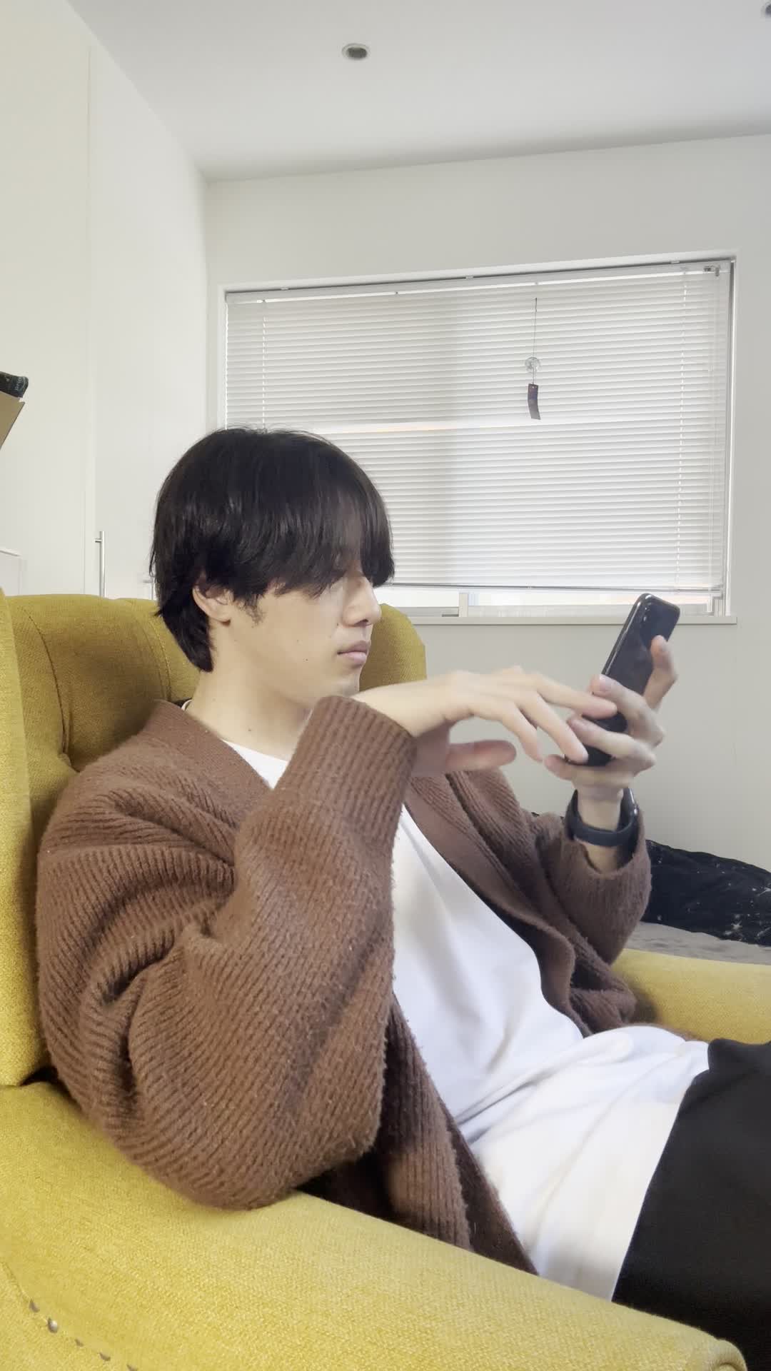 椅子に腰掛け、スマホの画面を見ながら「仕事頑張ろう！」と気合を入れる動作