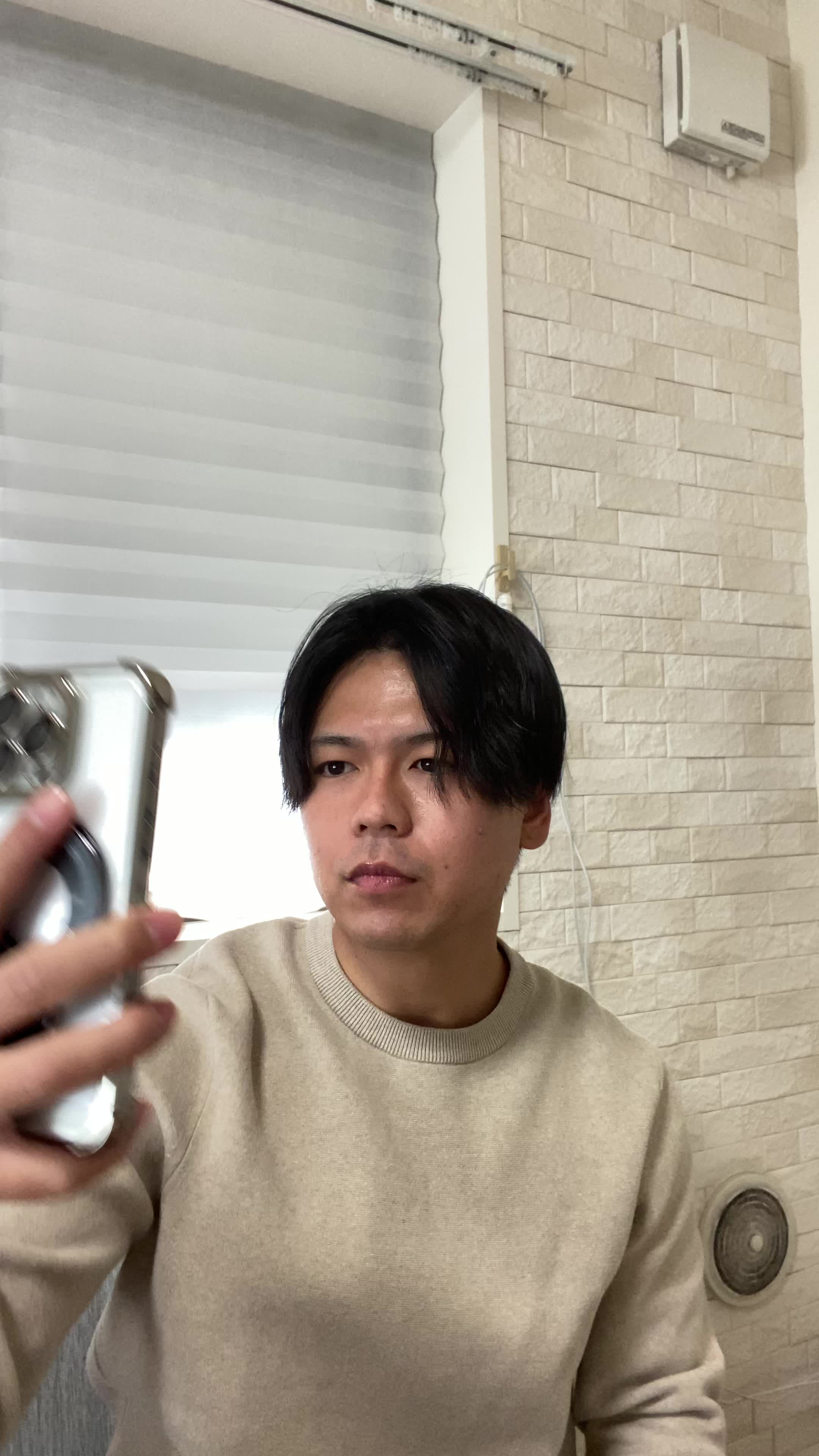椅子に浅く腰掛け、「歯の写真」をスマホで撮り、「ビフォーアフターを残しておこう」と思う動作