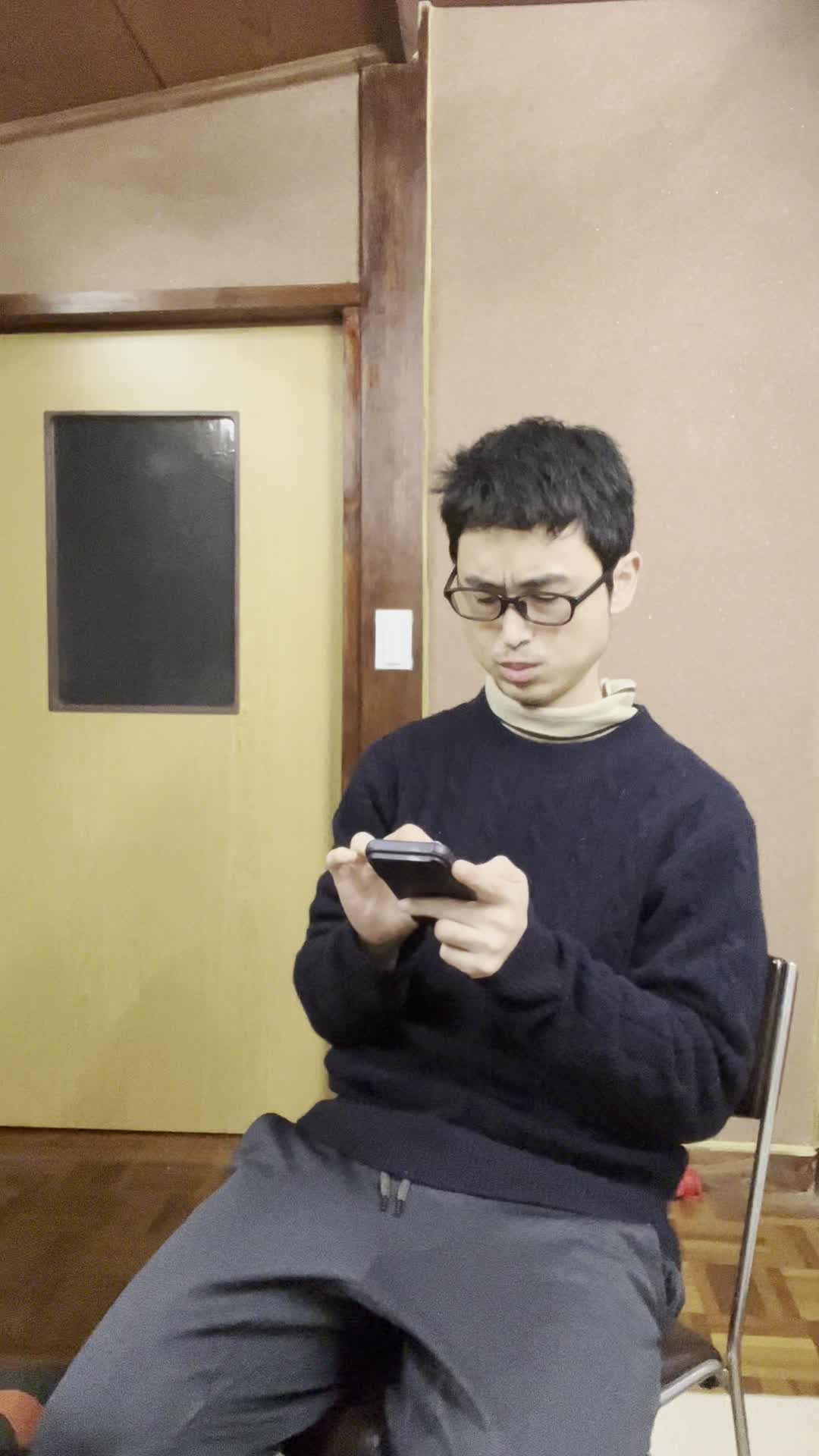 椅子に座り、スマホで求人情報を眺めながら「どれが自分に合うだろう」と悩む表情
