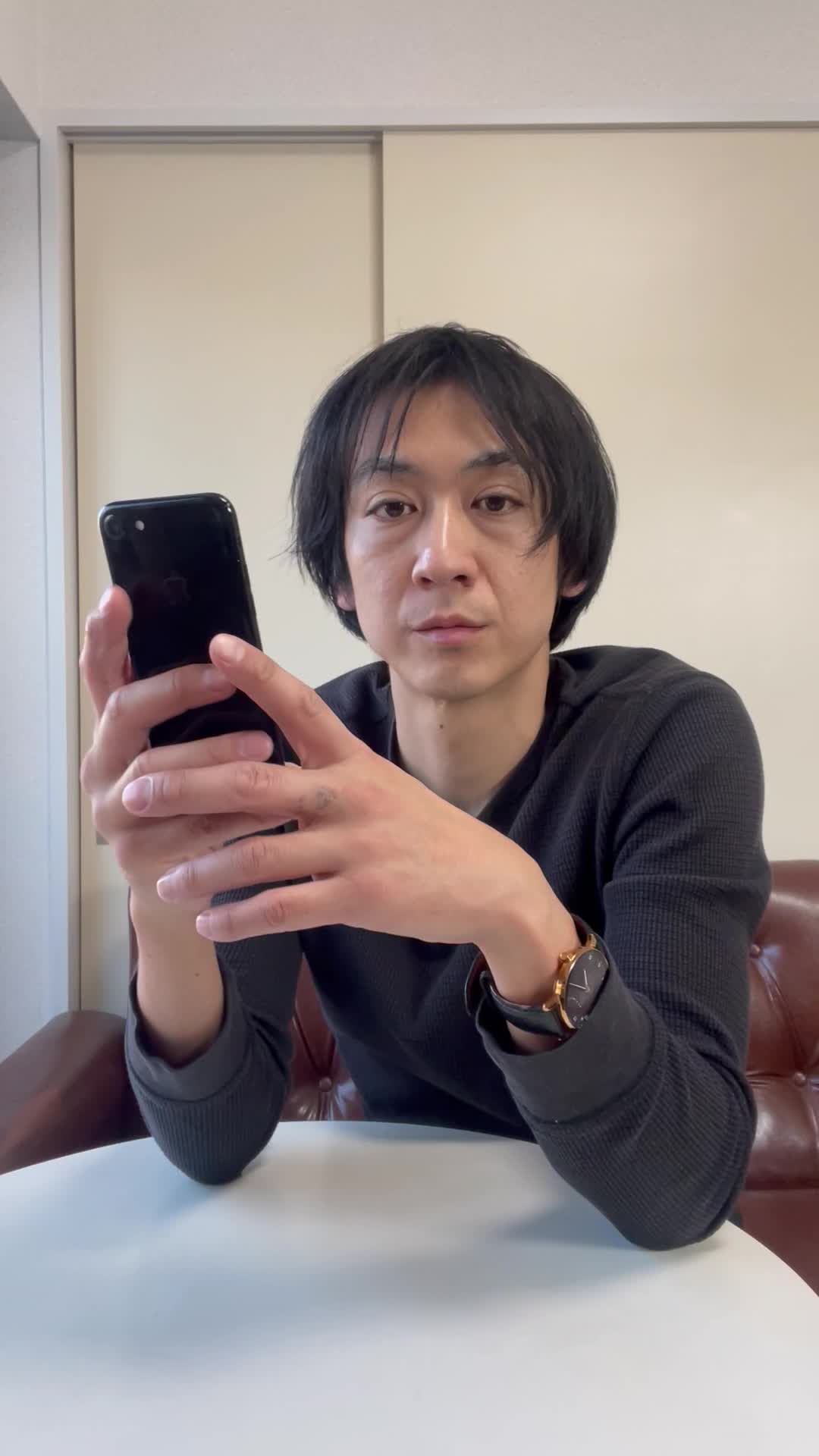 テーブルでスマホを見ながら、「便秘の原因を検索して悩む」真剣な表情