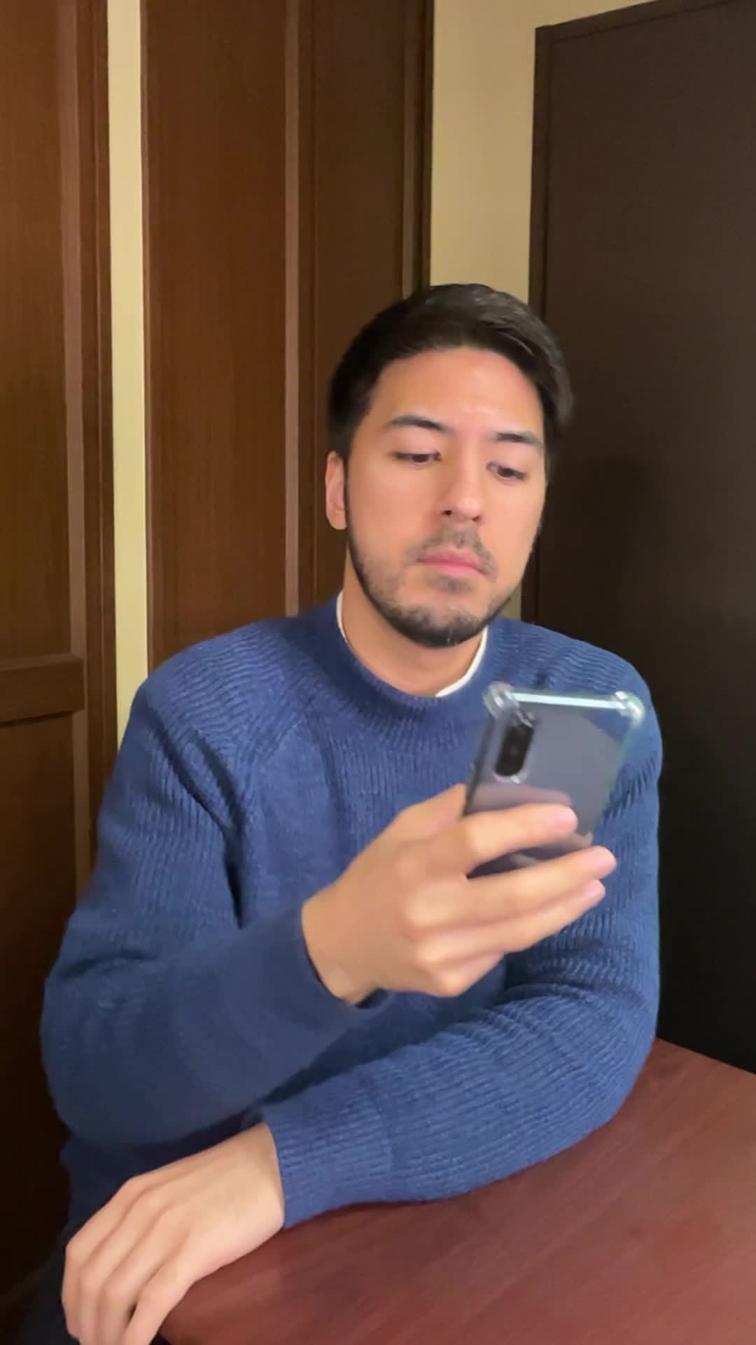 テーブルでスマホを操作しながら、「レビューを読んで納得する」真剣な表情