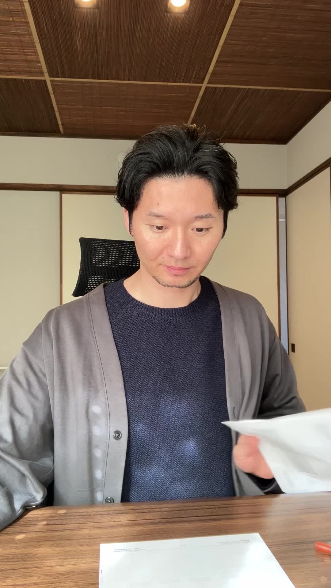 テーブルに広げた書類をまとめながら、「これで決まりかな」と満足する姿