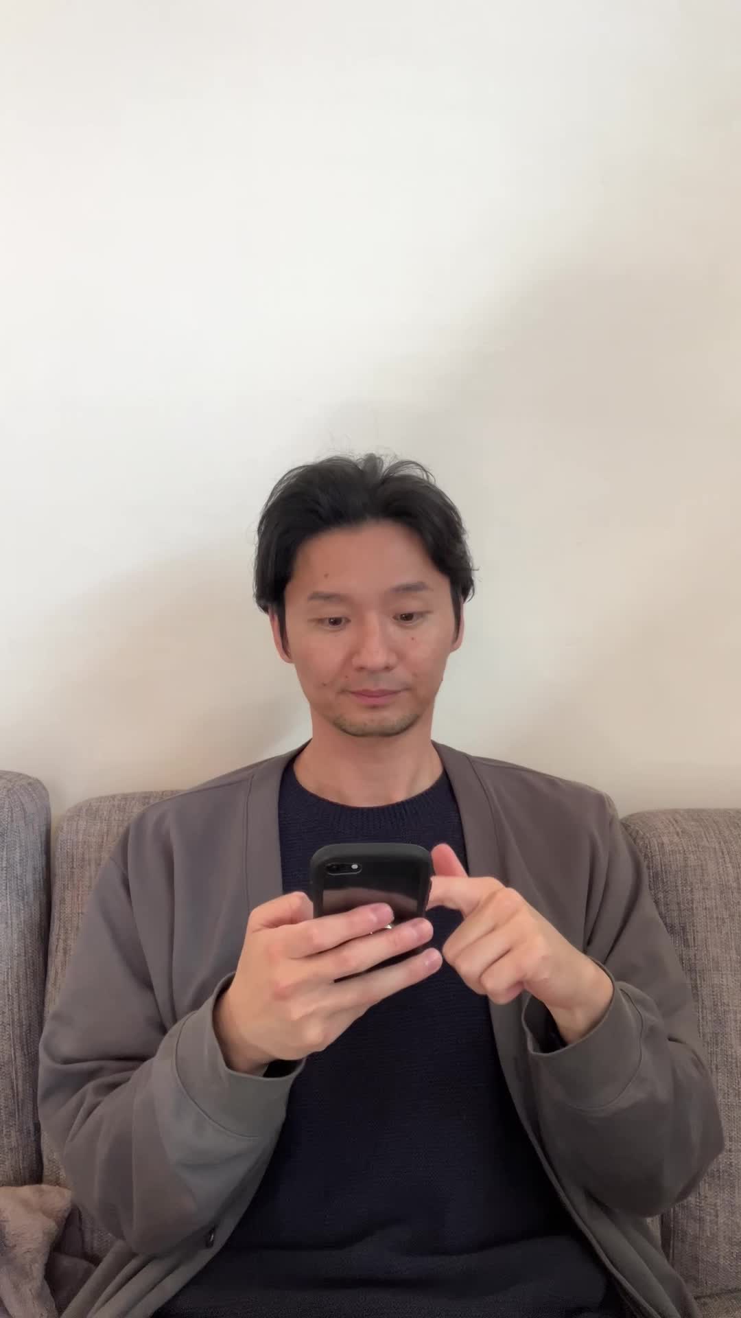 ソファでスマホを操作し、「保険の窓口」を検索してホッとした表情を見せる
