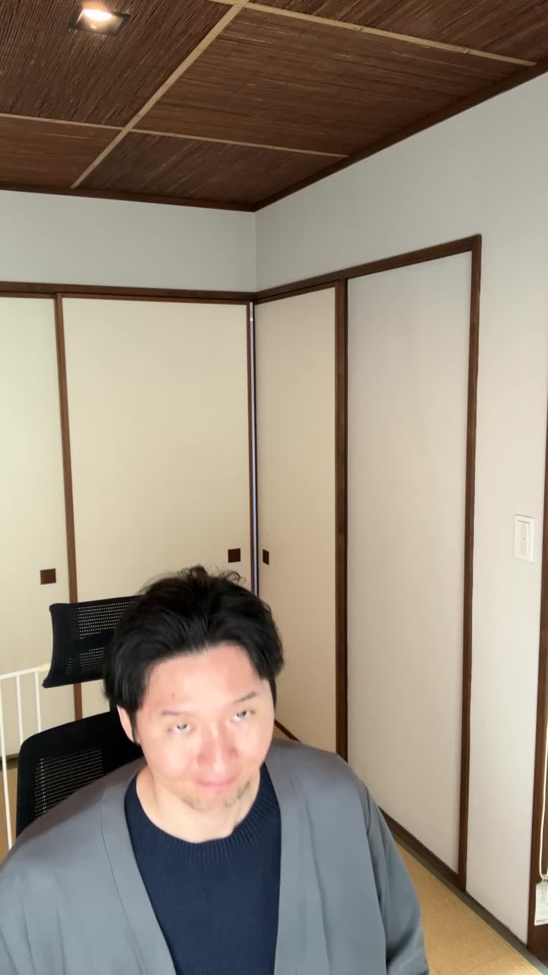 椅子から立ち上がり、「これで備えは万全」と自信を持つ笑顔を見せる動作