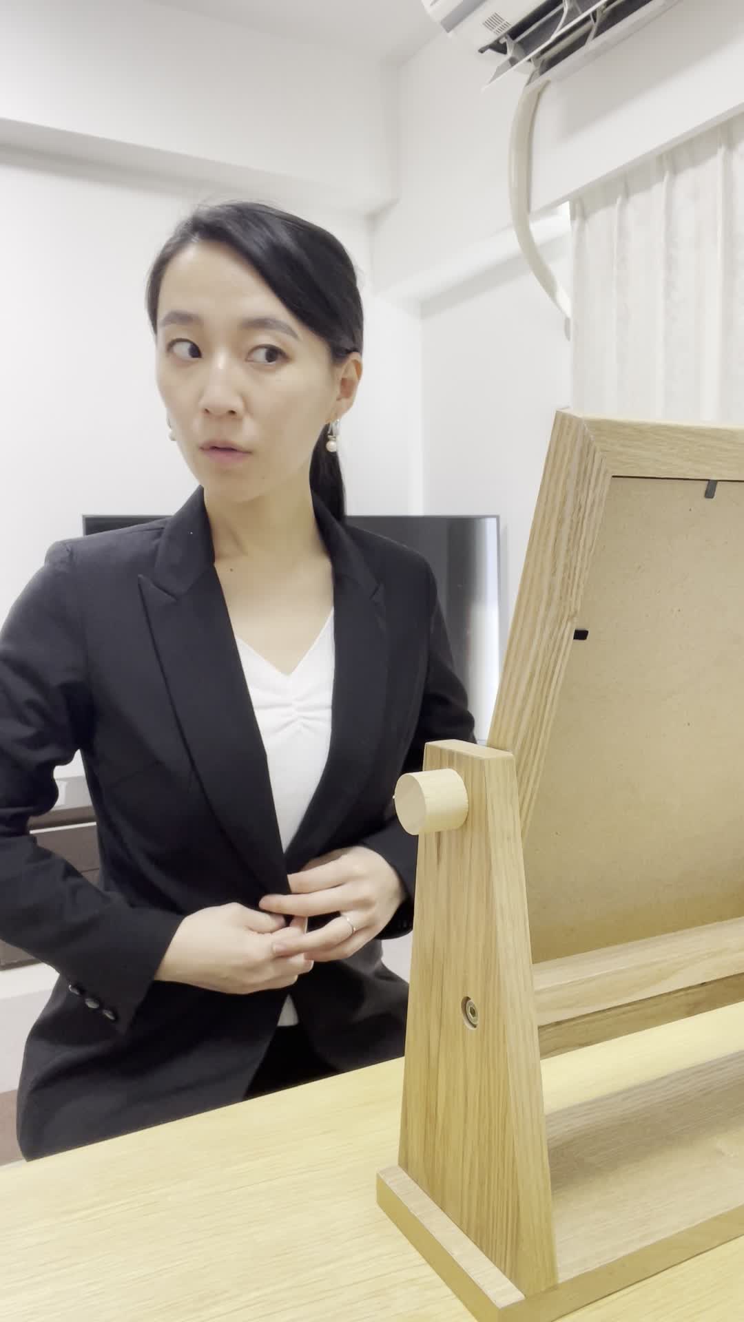 スーツを試着し、鏡の前で身だしなみを整えている