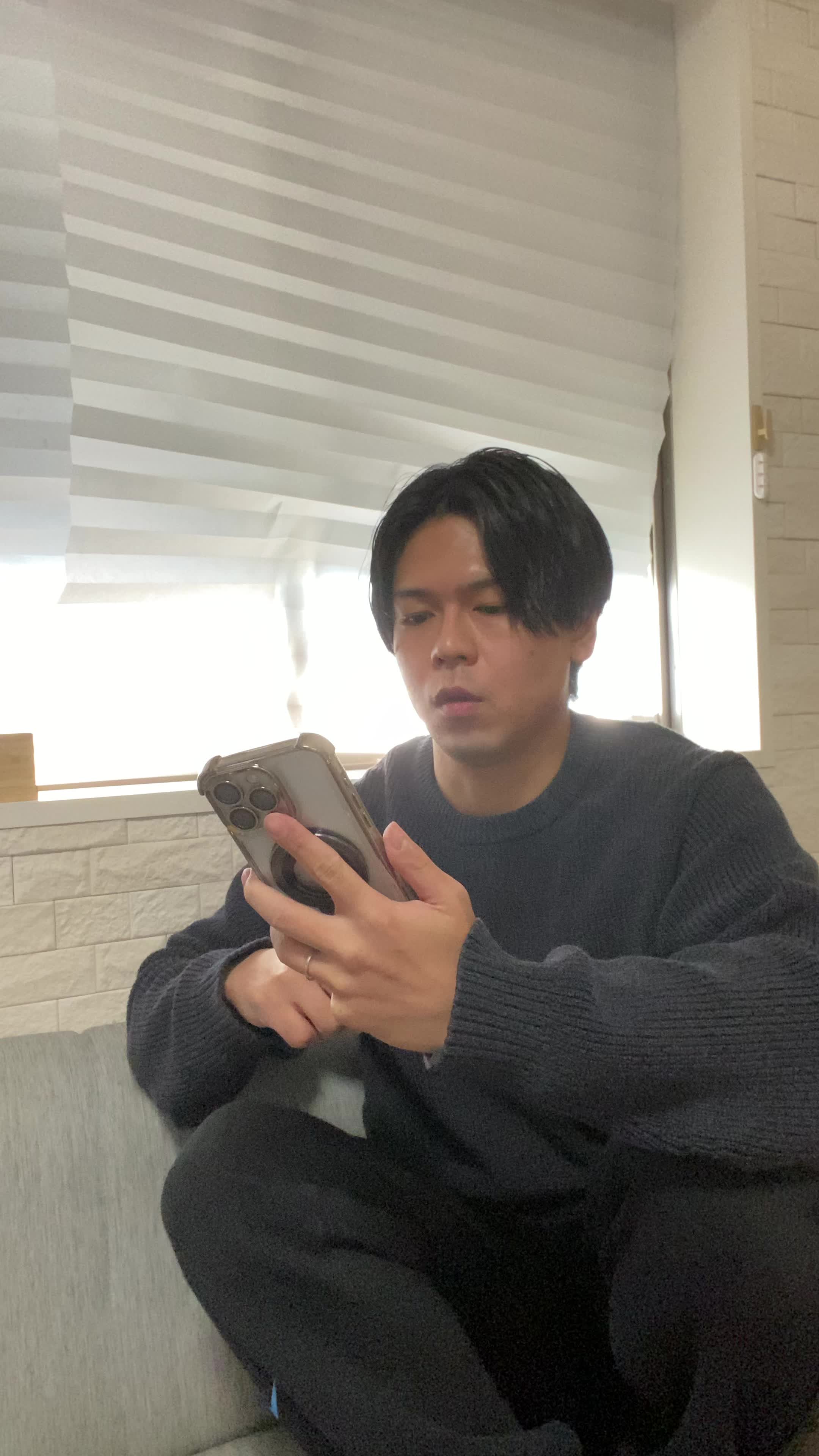 ソファで友達と話しながら、「これが新作だよね！」と嬉しそうに見せる姿