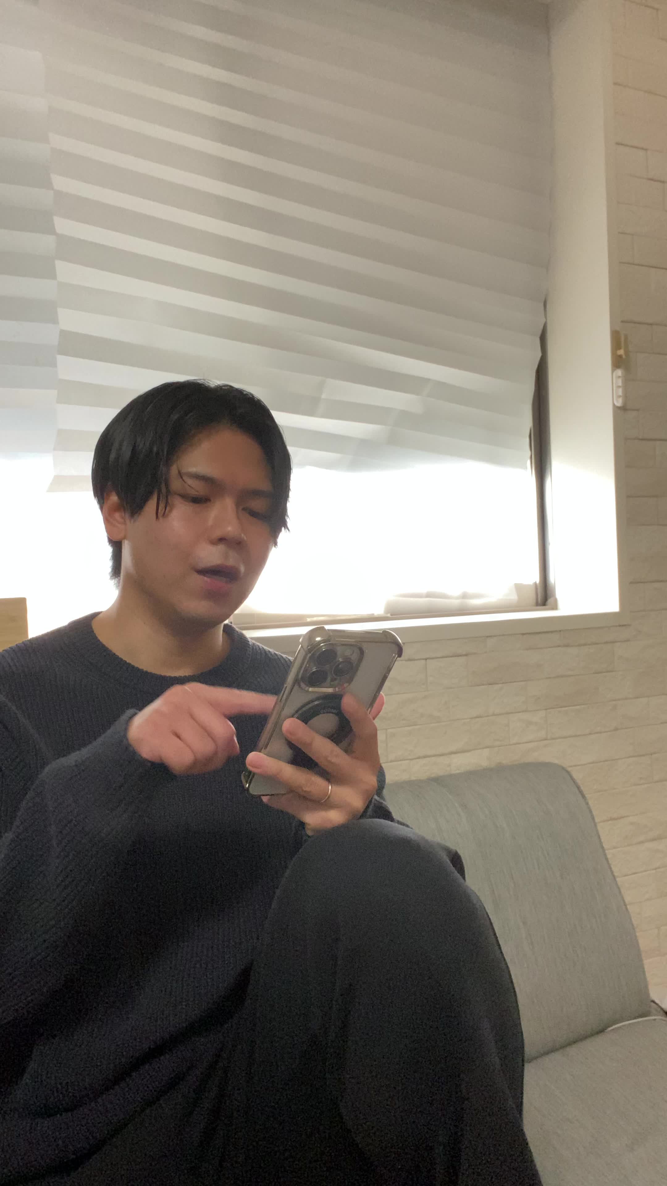 ソファでスマホを見ながら、「友達におすすめアイテムを共有する」楽しそうな表情