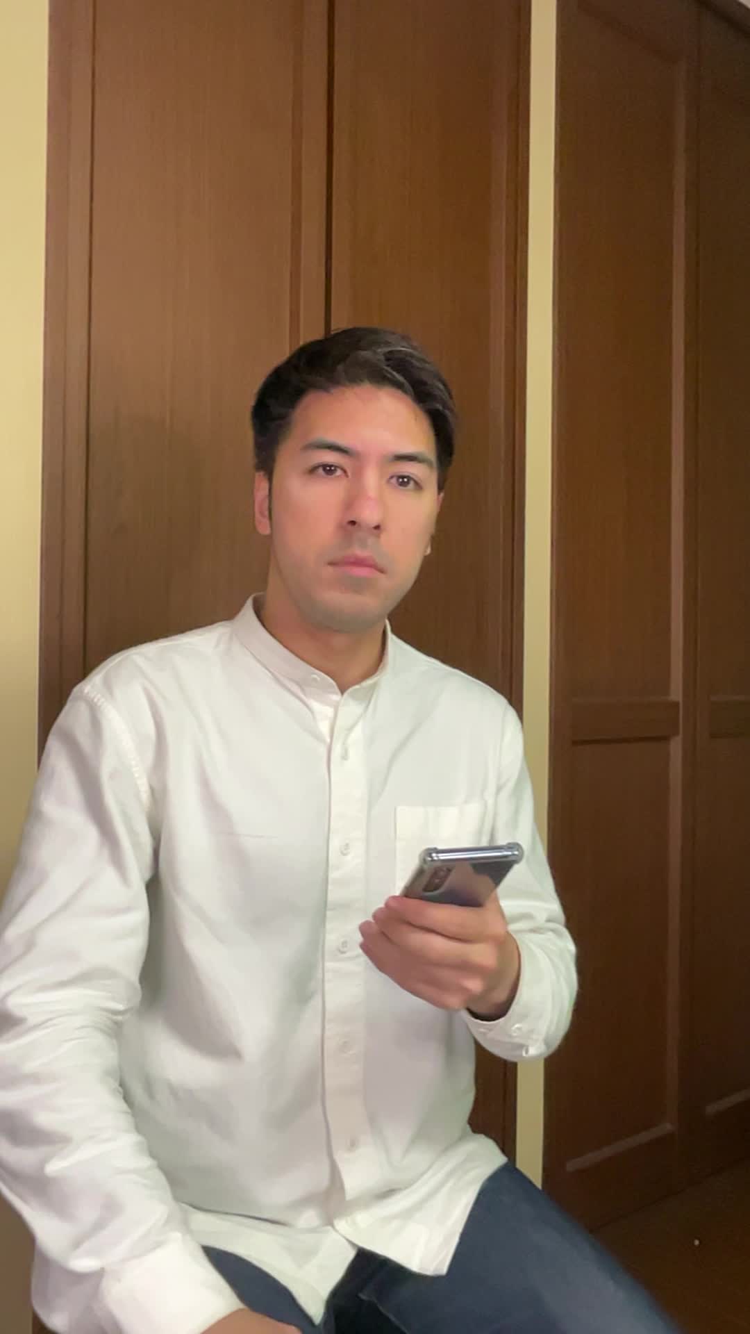 椅子に腰掛け、スマホの画面を見ながら「体臭ケアの口コミを読んで安心する」表情