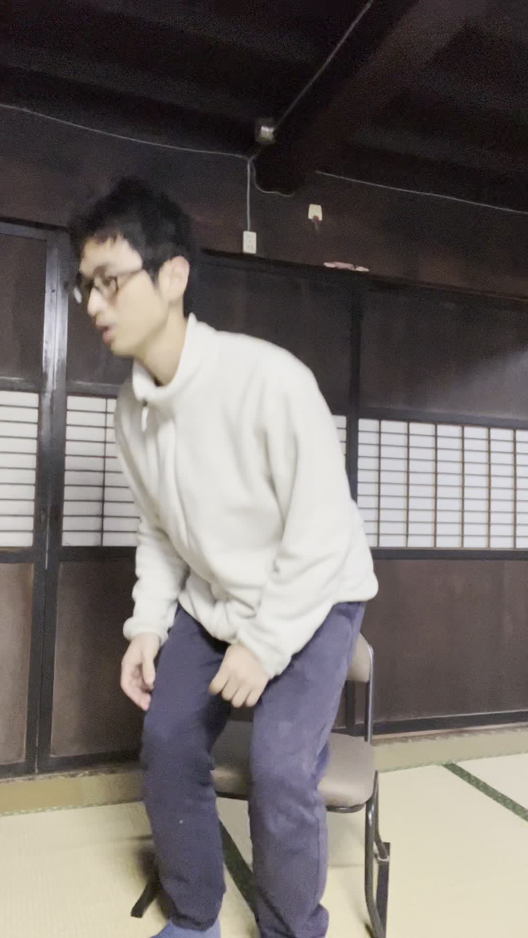 椅子に座り、お腹を軽く押さえながら「ずっと痛みが続いている…」と苦しそうな表情