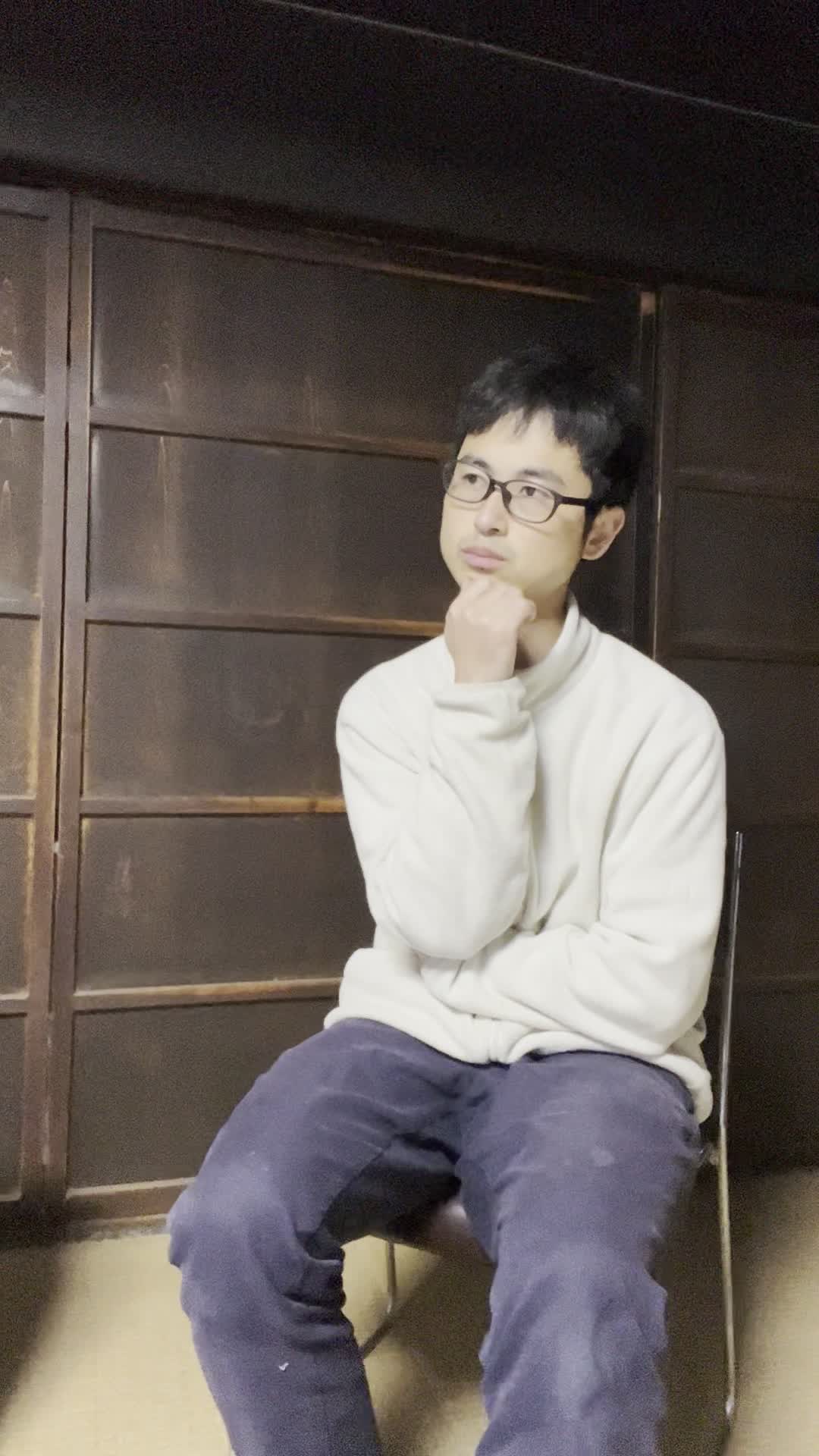 椅子に浅く腰掛け、「腸活サプリメントを試すべきか迷う」悩ましげな表情