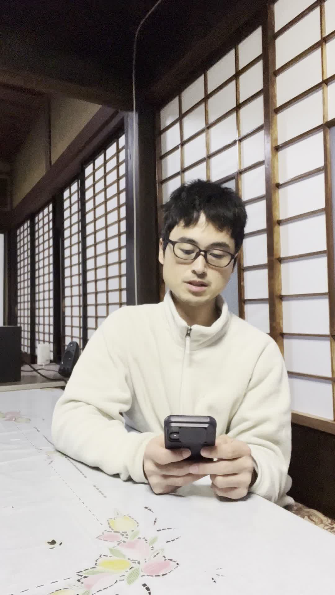 テーブルでスマホを見ながら、「便秘の原因を検索して悩む」真剣な表情