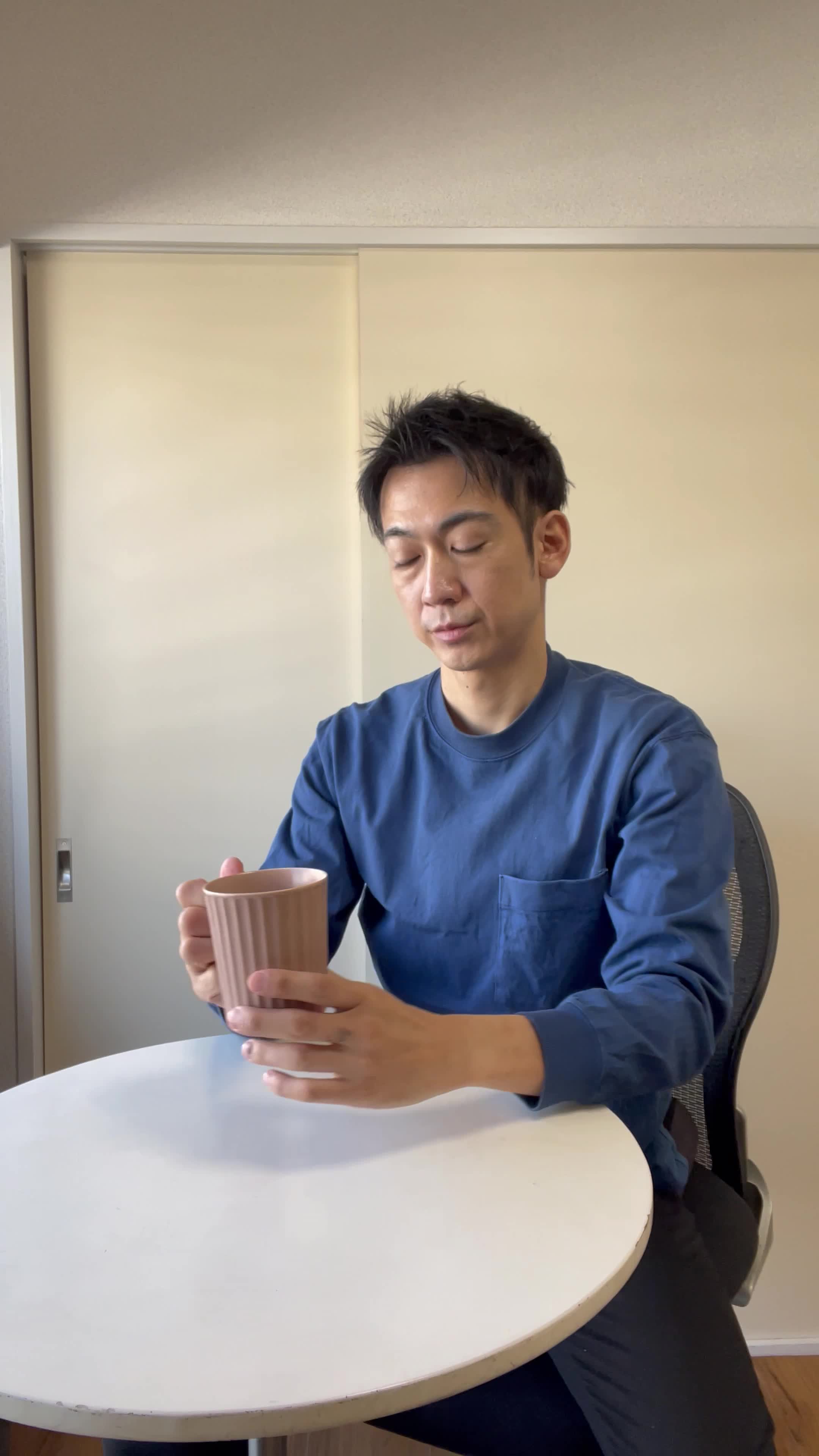 椅子に浅く腰掛け、「飲み物で少しでも元気を取り戻せる？」と悩む様子