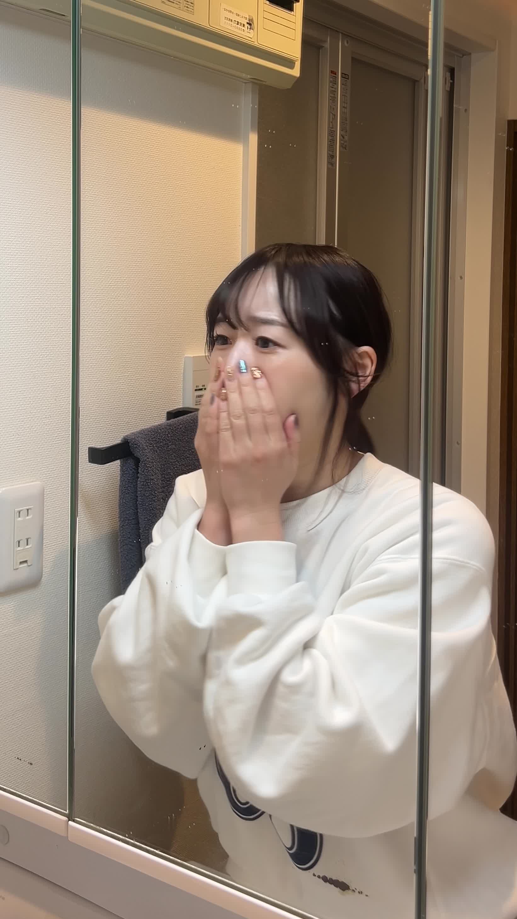 鏡の前で口元を手で隠しながら「どうしよう…」と困った表情をする