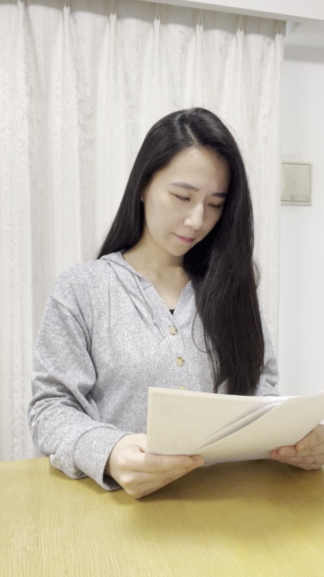 テーブルで車の査定書を手に取り、真剣に見つめている様子