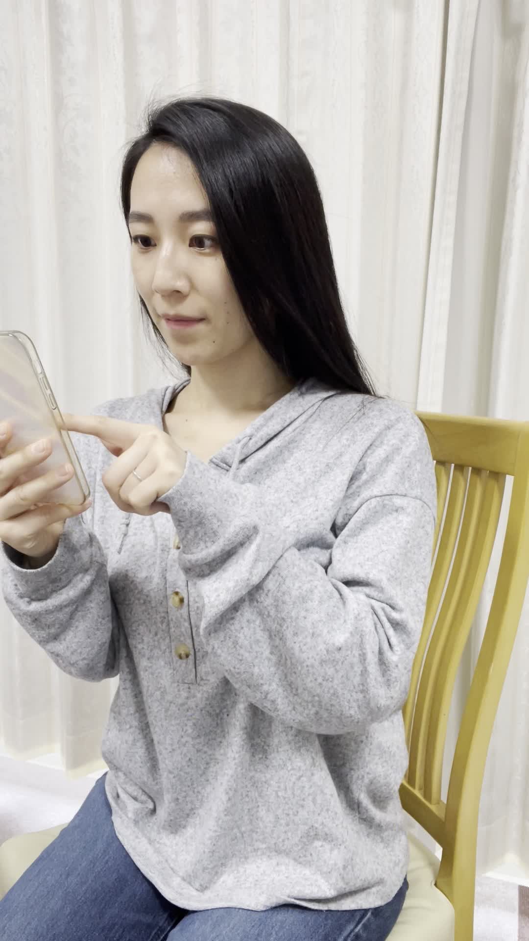 椅子に腰掛け、スマホで査定フォームを入力しながら期待する顔