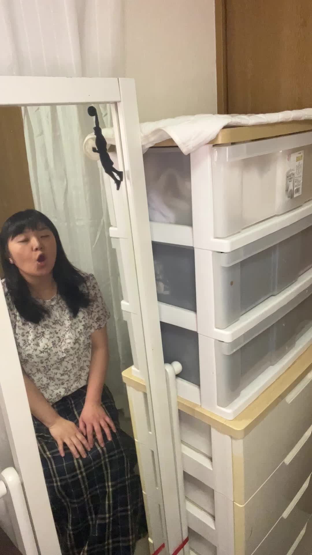 椅子から立ち上がり、全身鏡を見て「これで行こう」と決意する仕草