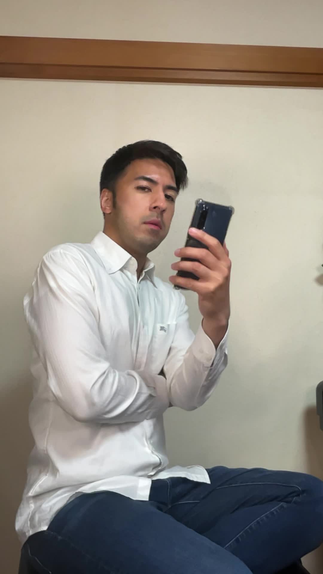 椅子に座り、スマホで求人情報を眺めながら「どれが自分に合うだろう」と悩む表情