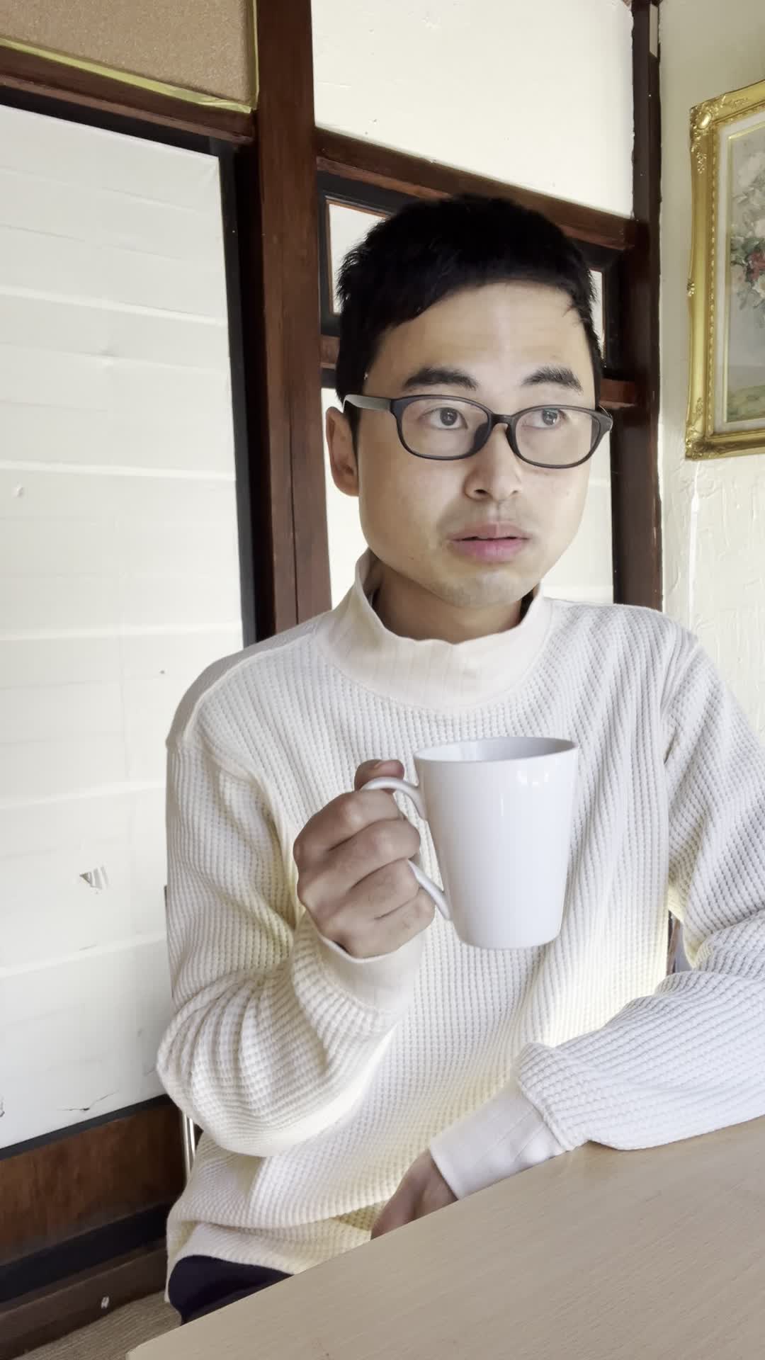 椅子に浅く腰掛け、「飲み物で少しでも元気を取り戻せる？」と悩む様子