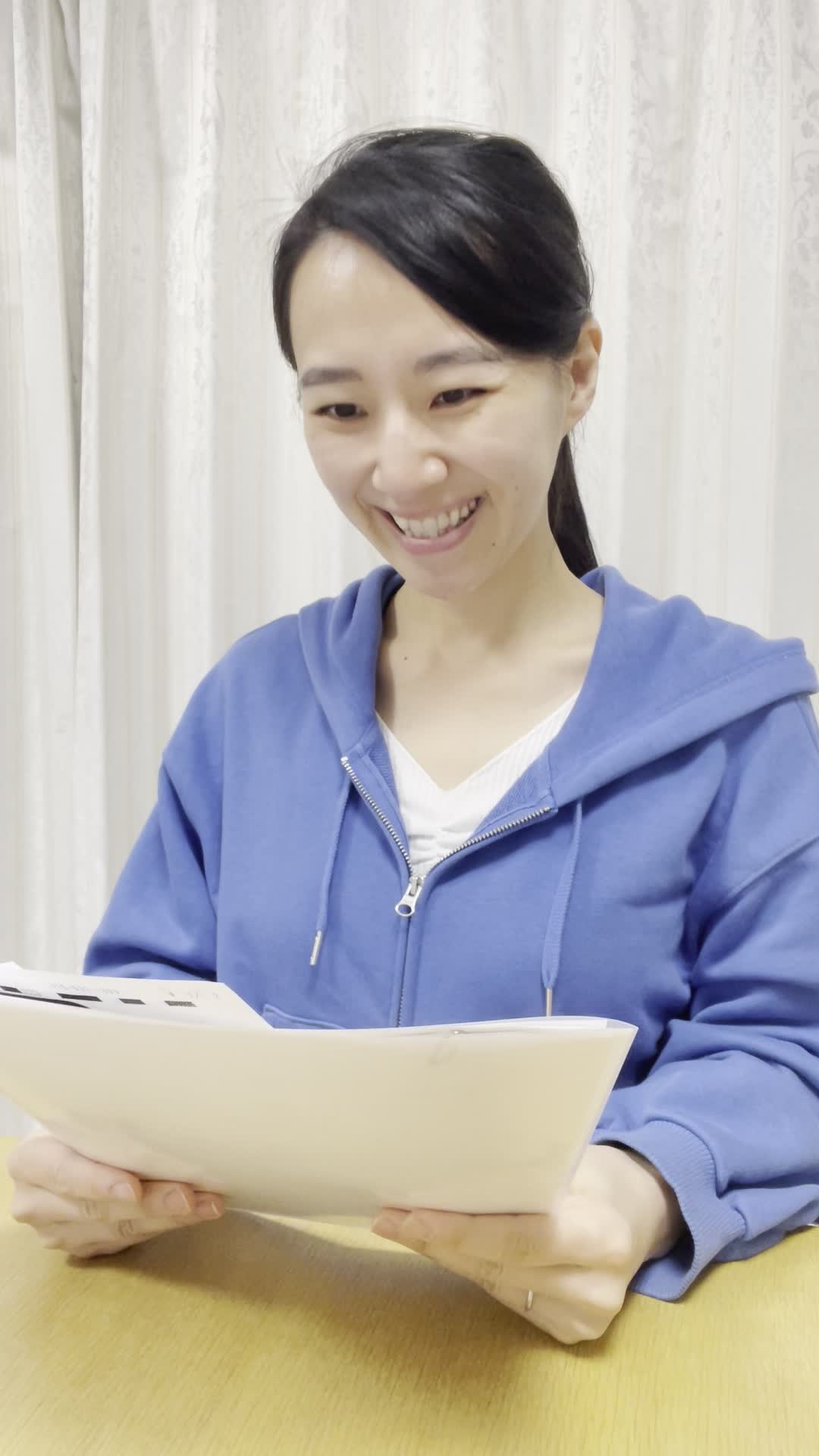 テーブルで脱毛のプラン表を広げ、「これなら私でも行けそう！」と笑顔を浮かべる顔