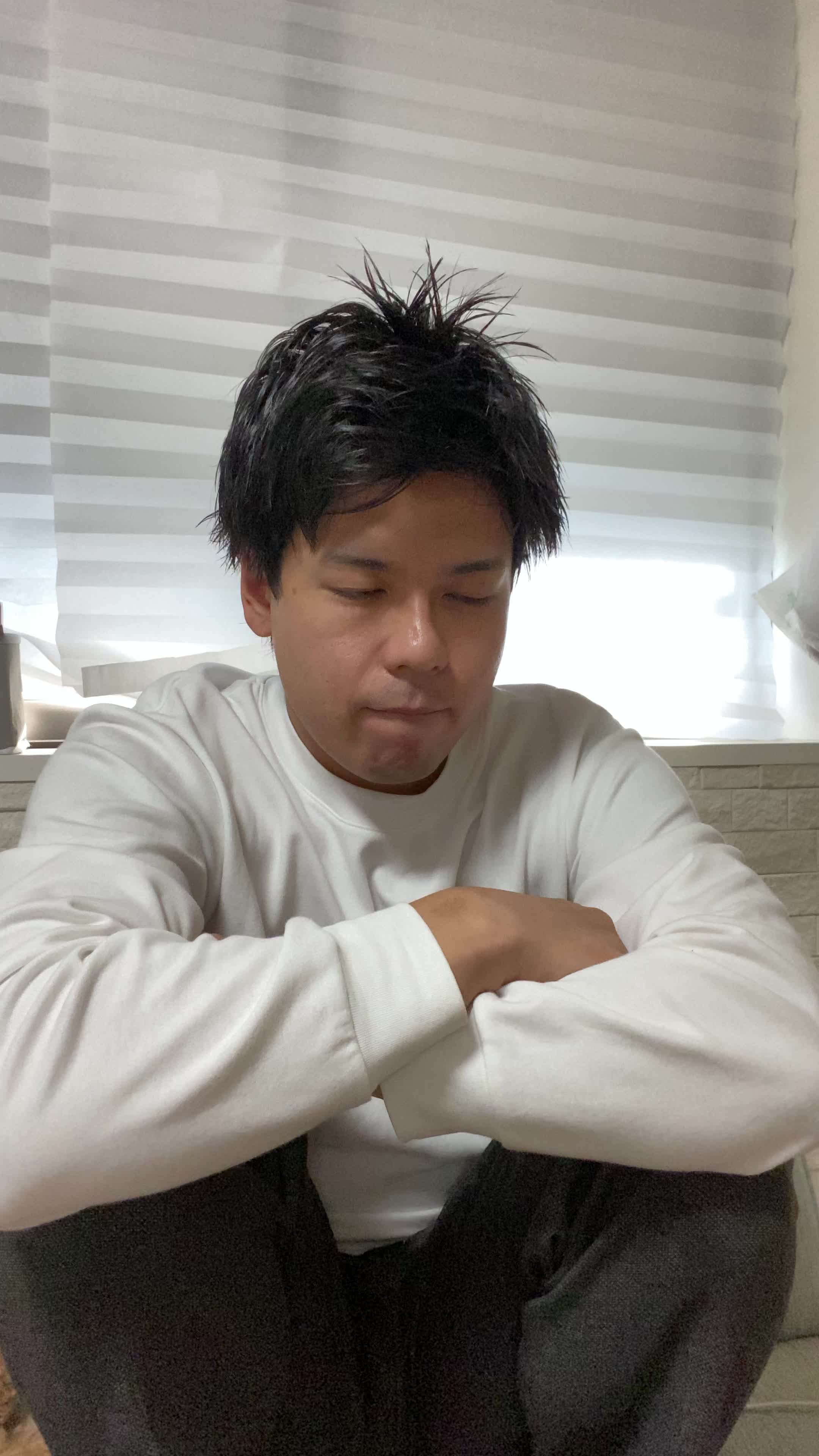 ソファでクッションを抱え、「これで匂いが改善するかな？」と悩む真剣な表情