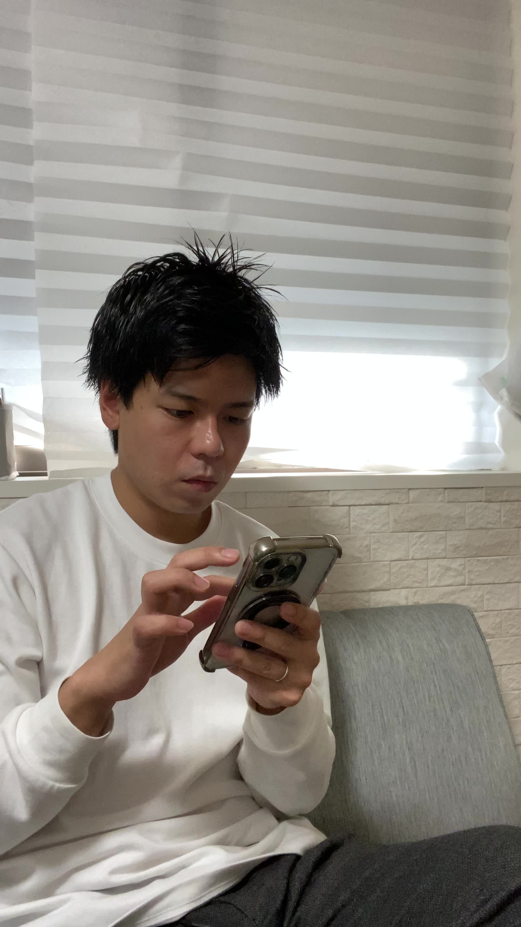 テーブルでスマホを操作しながら、「体臭ケアのおすすめ商品を調べる」集中した様子