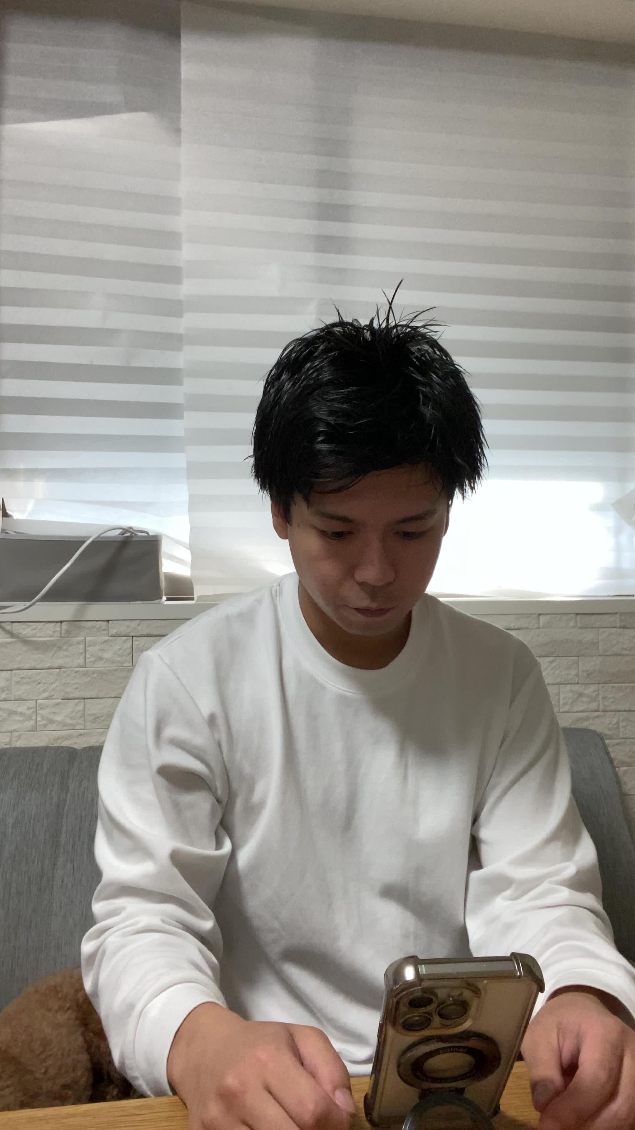テーブルに置いたスマホを見ながら、「新しいケア方法を試す決意を固める」動作