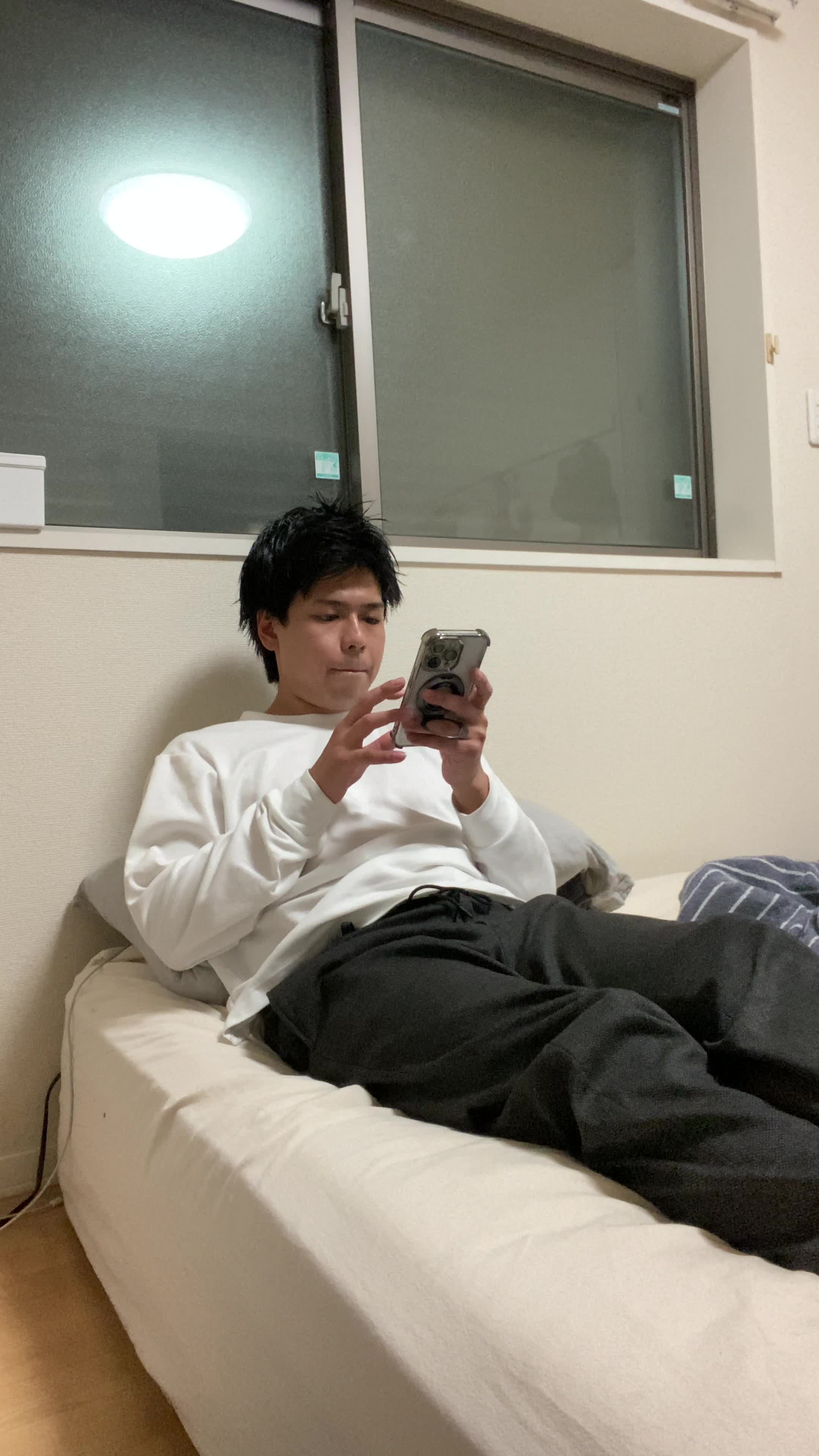 ベッドで脚を伸ばし、「体臭ケアでどれくらい効果が出るか調べる」期待の表情