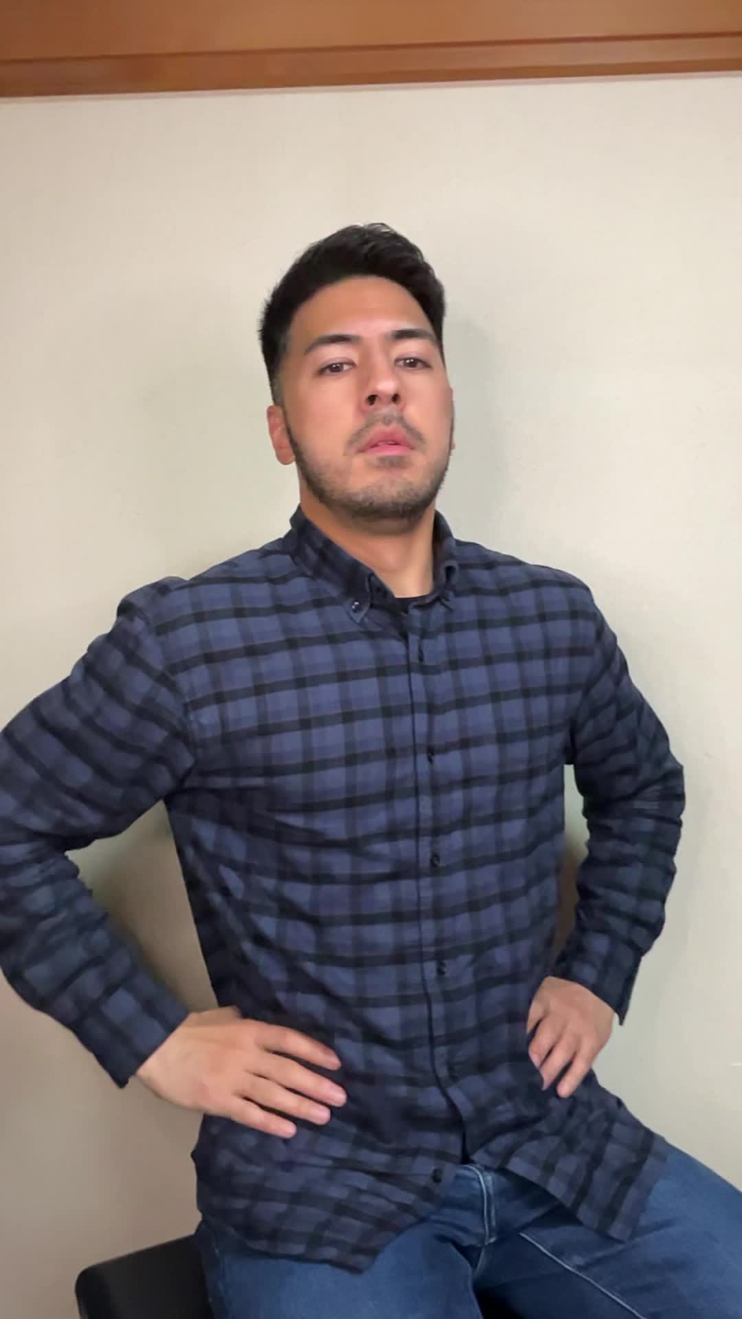 椅子に浅く腰掛け、「腸活サプリメントを試すべきか迷う」悩ましげな表情