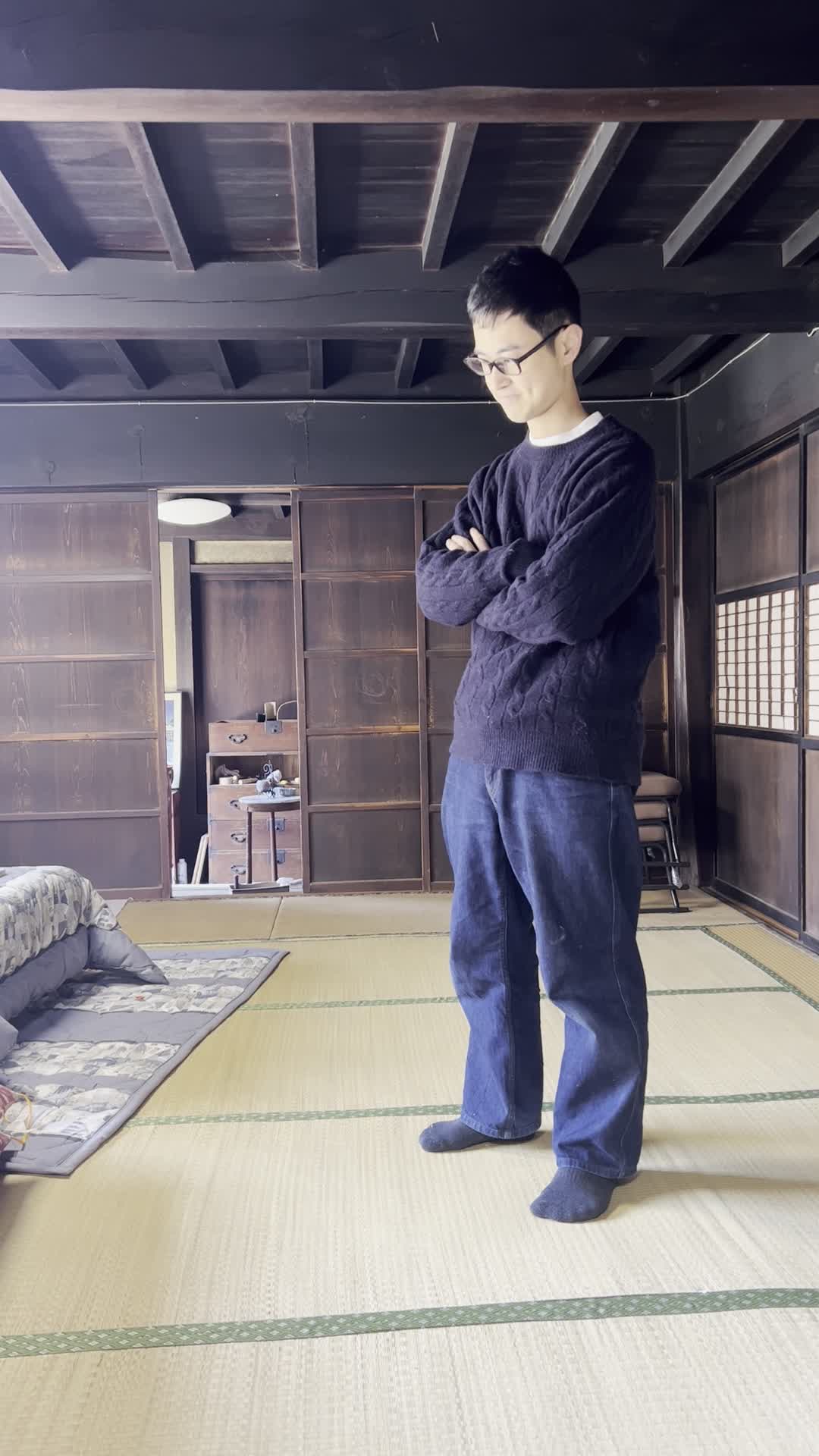 部屋の中心で腕を組みながら考え込む