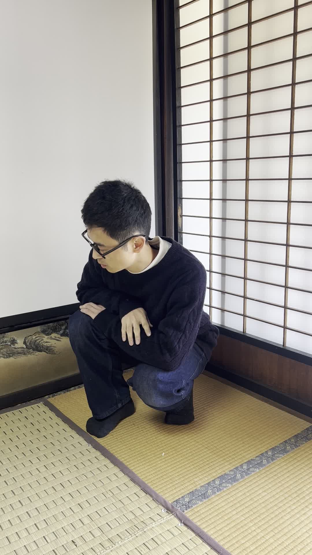 部屋の片隅でしゃがみ込み、何かを探しているような動作