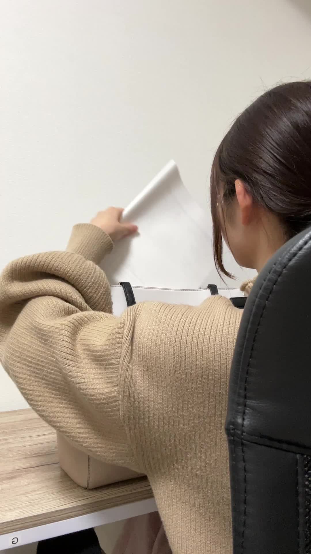 カバンから書類を取り出す手元