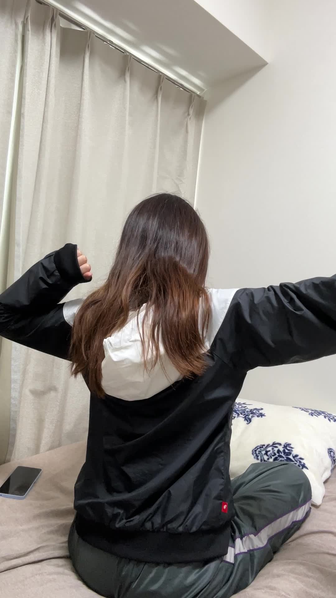 ベッドの上で伸びをする後ろ姿