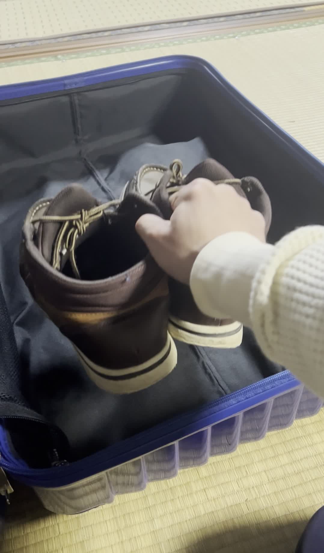 ファスナーを開けてスーツケースを開く手元