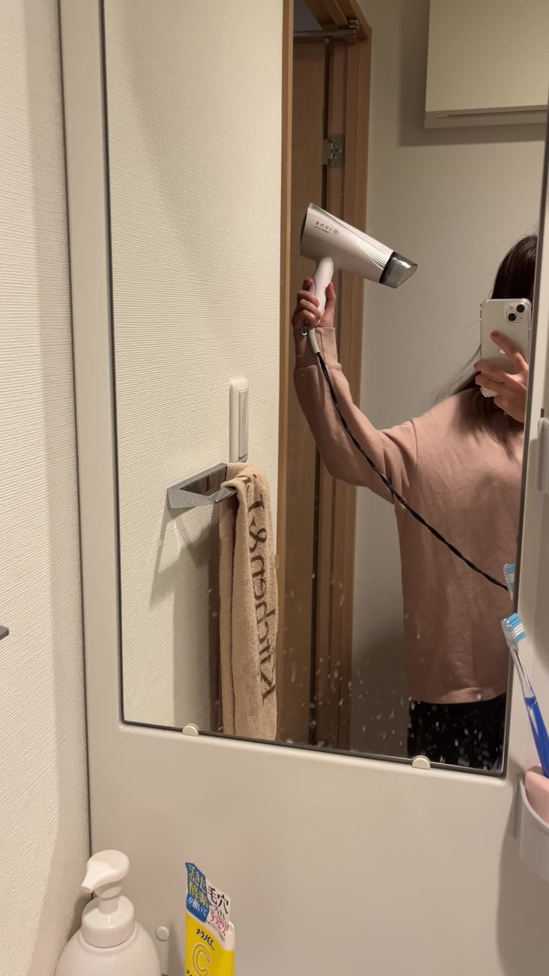 ドライヤーで髪を乾かす手元