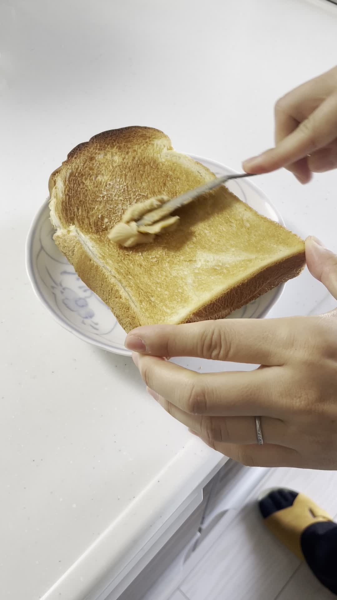 トーストにバターを塗る手元
