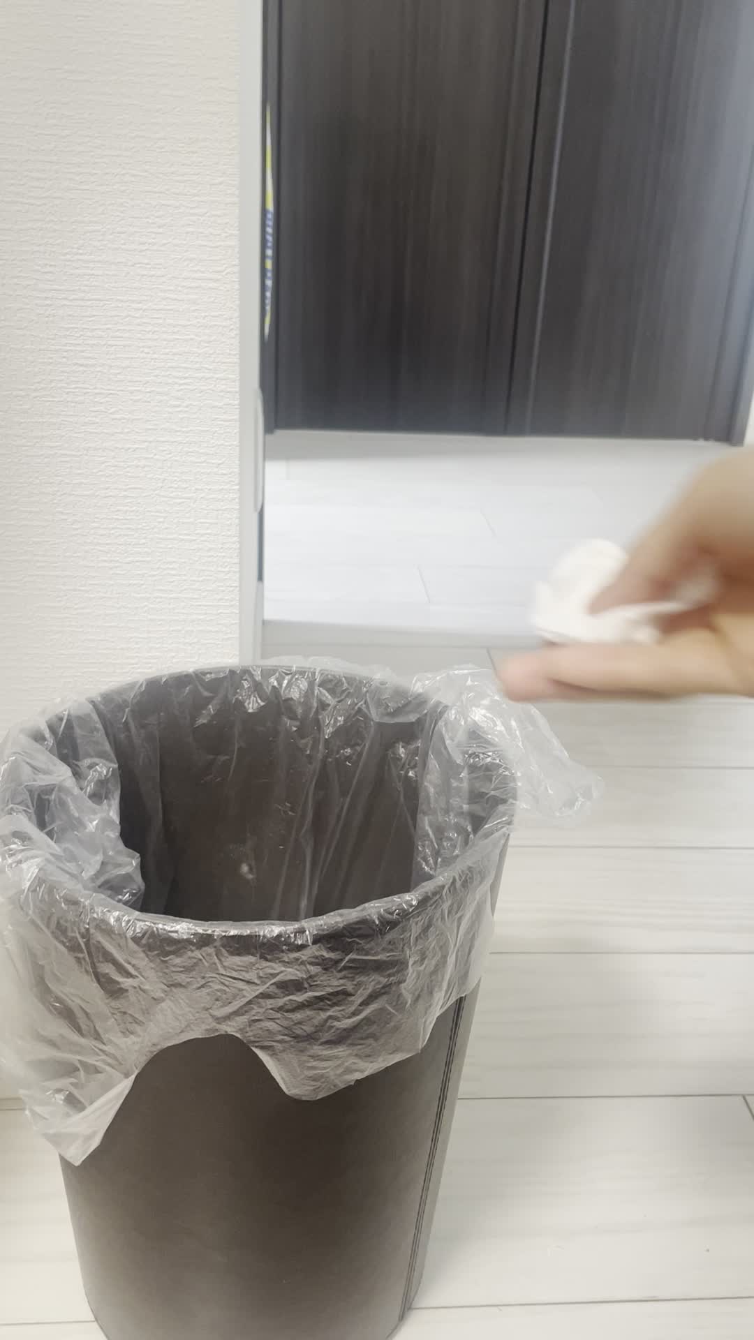 ゴミ箱に紙を捨てる手元