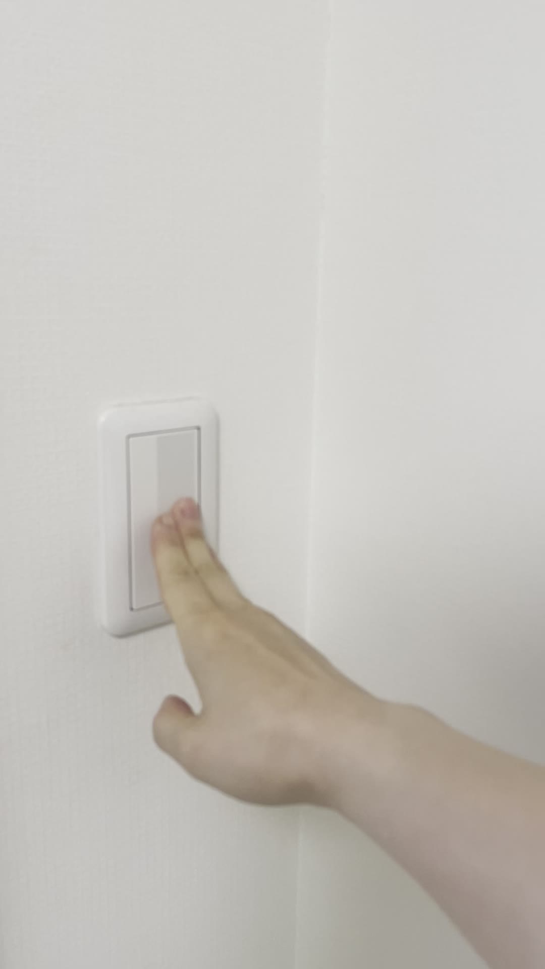 部屋の照明を落とす手