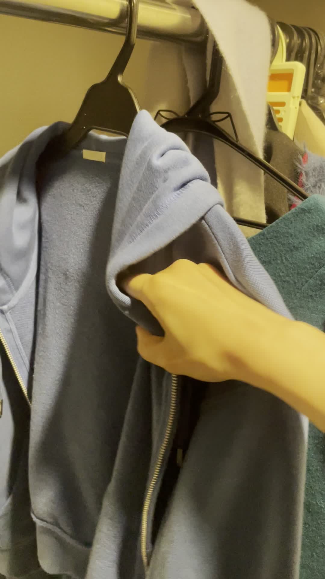 服をハンガーにかける手元