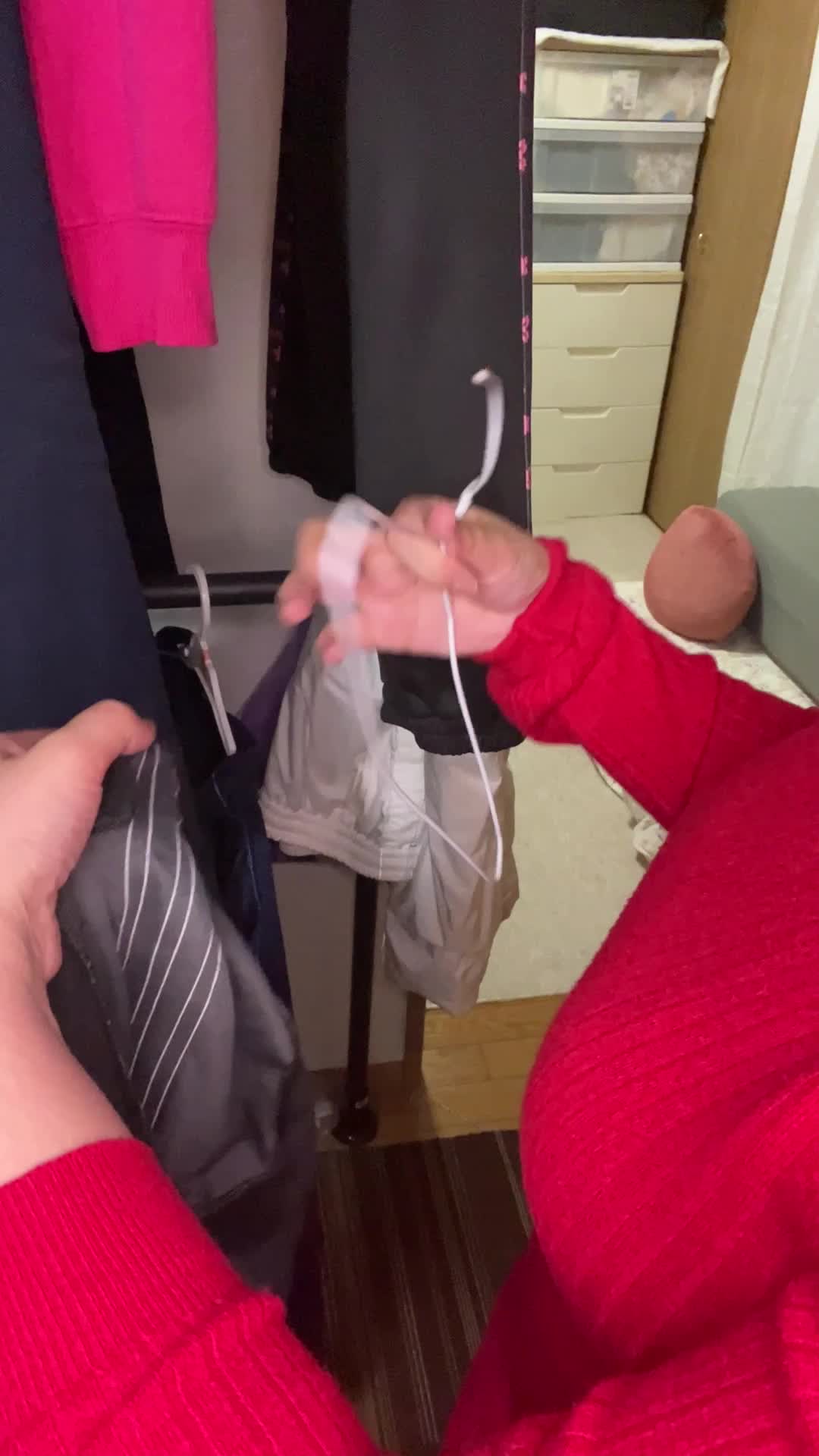 服をハンガーにかける手元