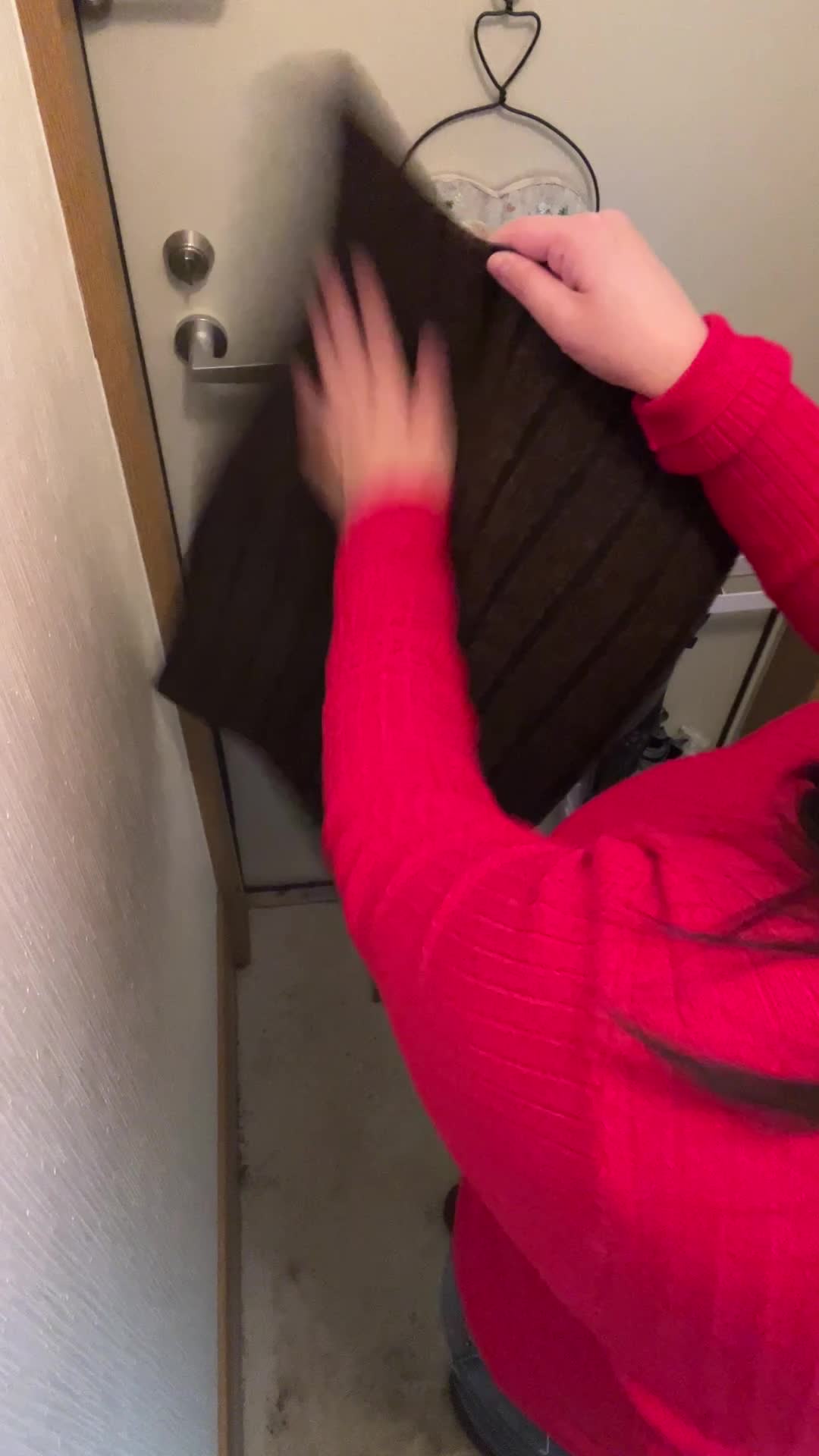 玄関マットを叩く手