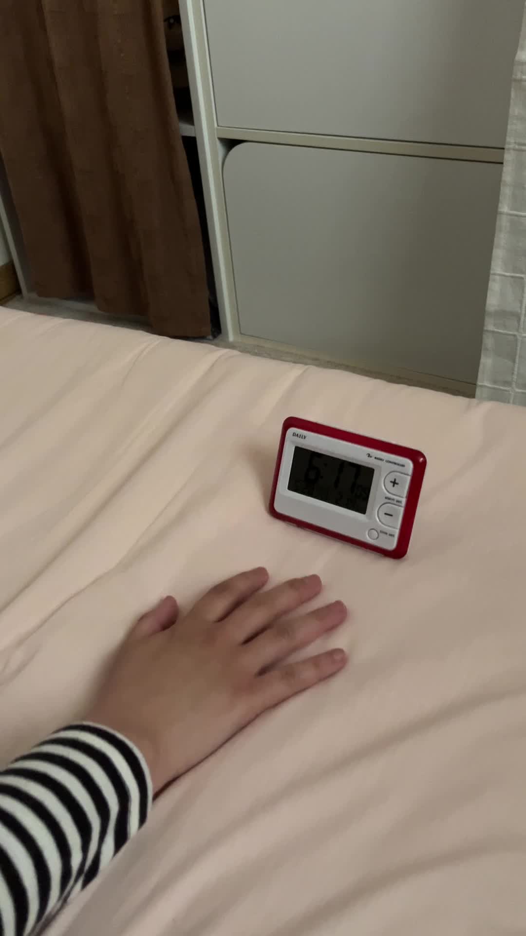 目覚め良く、目覚まし時計を止める手