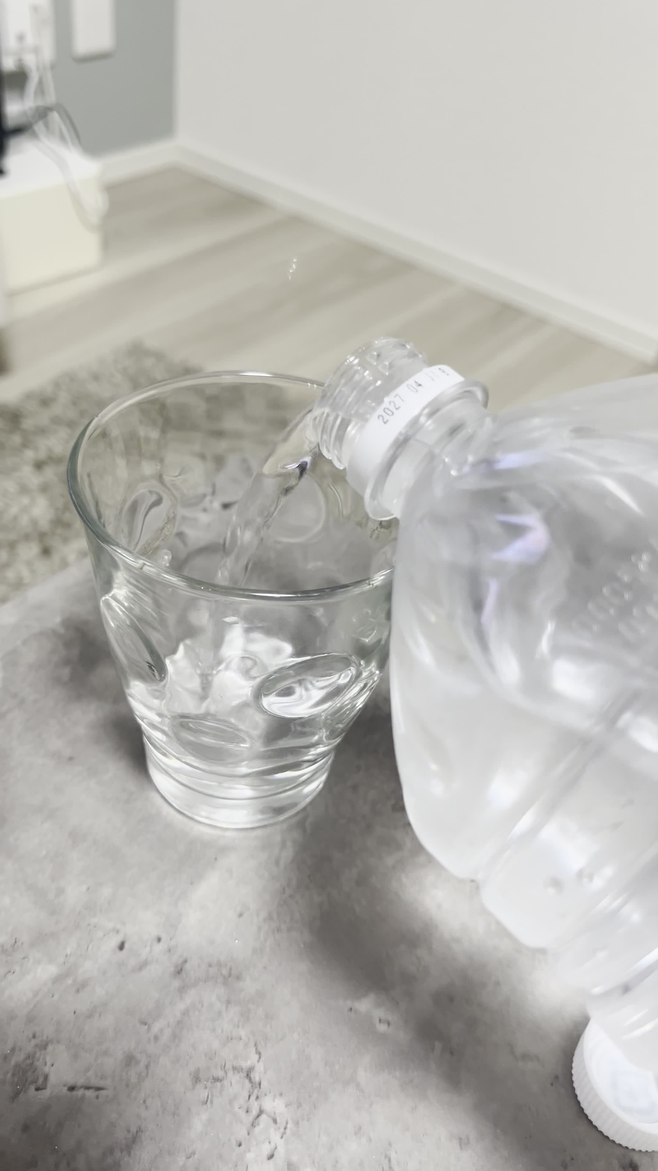グラスに水を注ぐ手元