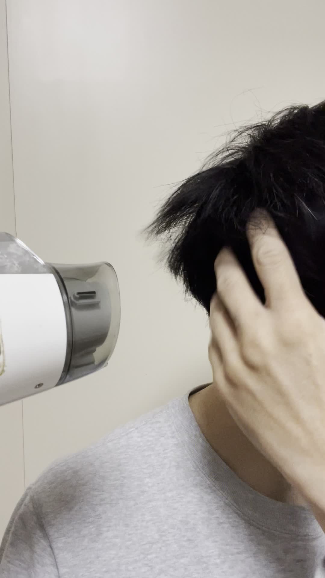 ドライヤーで髪を乾かす手元