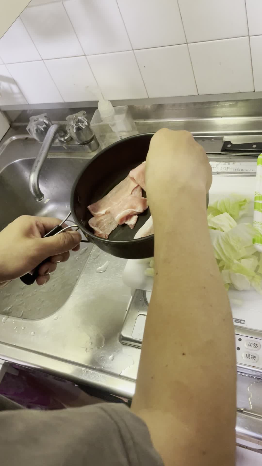 具材をフライパンに入れる手