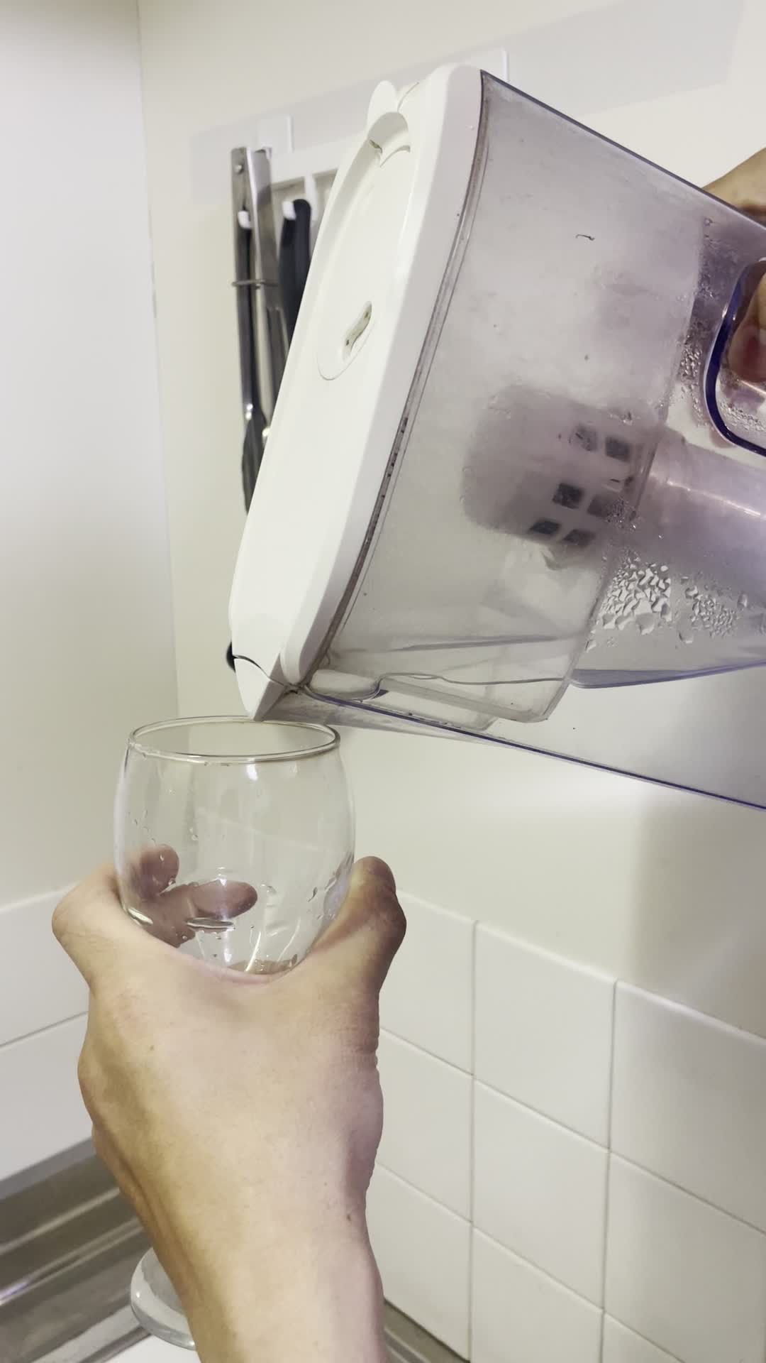 グラスに水を注ぐ手元